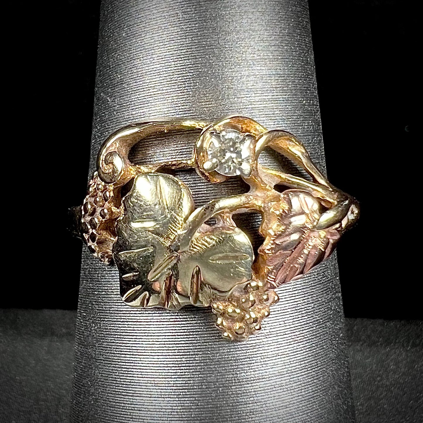 A ladies' two tone rose and yellow gold Black Hills gold diamond ring.  The ring exhibits a leaf design.