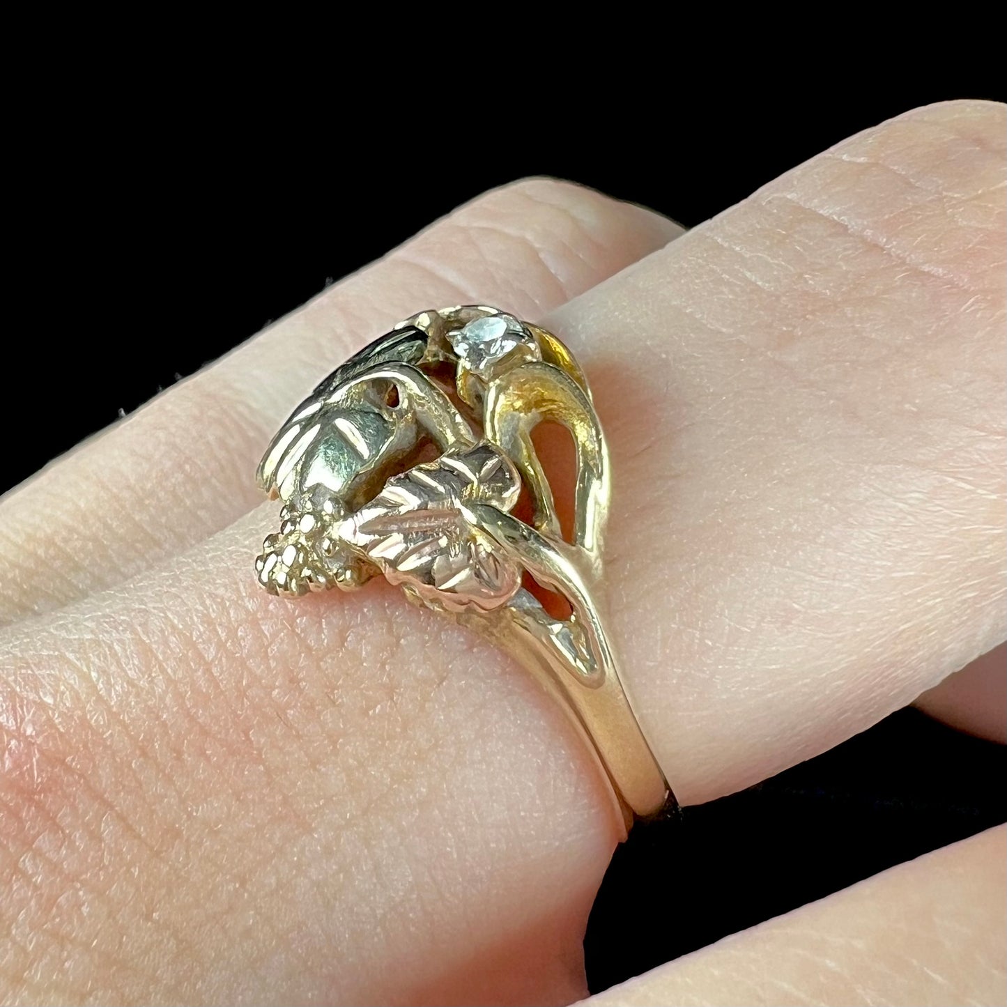 A ladies' two tone rose and yellow gold Black Hills gold diamond ring.  The ring exhibits a leaf design.