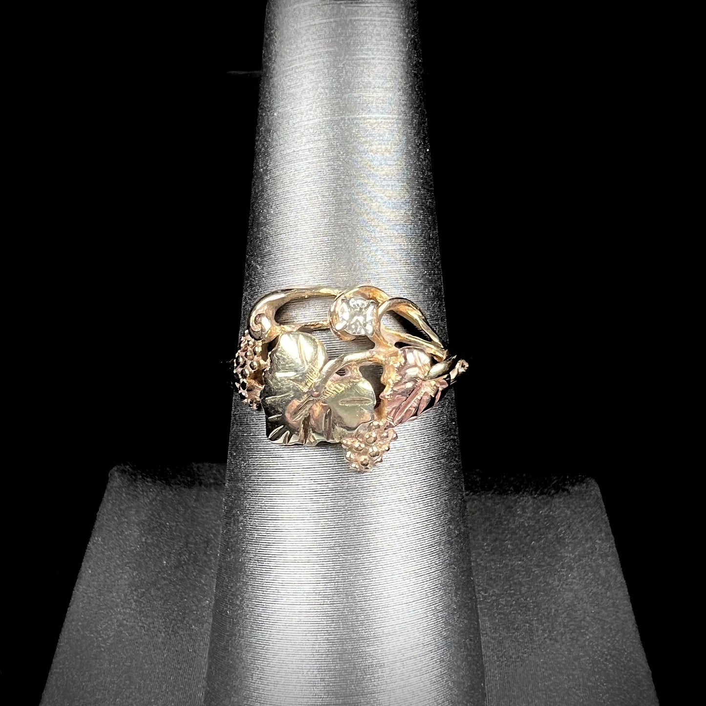 A ladies' two tone rose and yellow gold Black Hills gold diamond ring. The ring exhibits a leaf design.