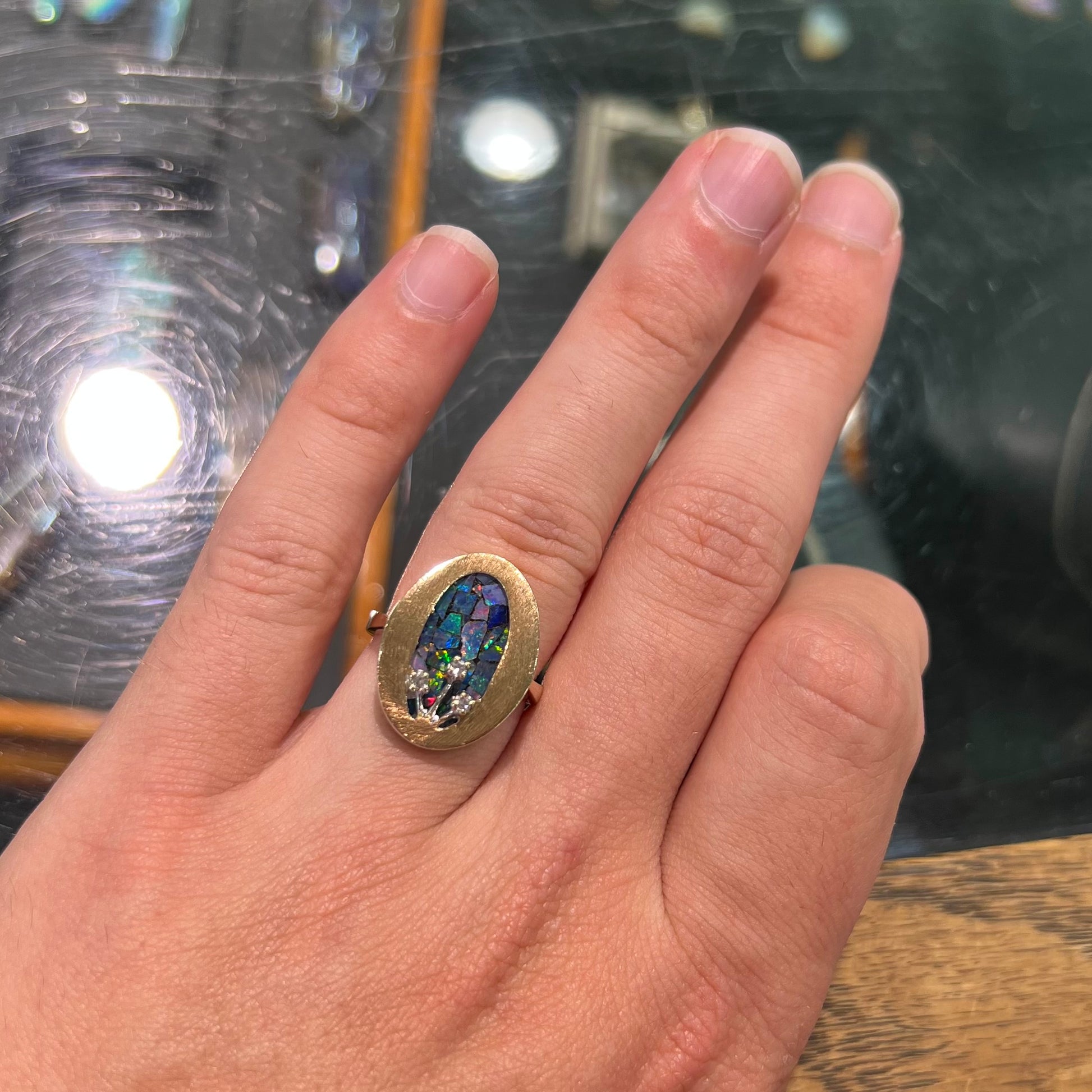 A vintage mosaic opal ring set with diamond accents in 10 karat yellow and white gold.