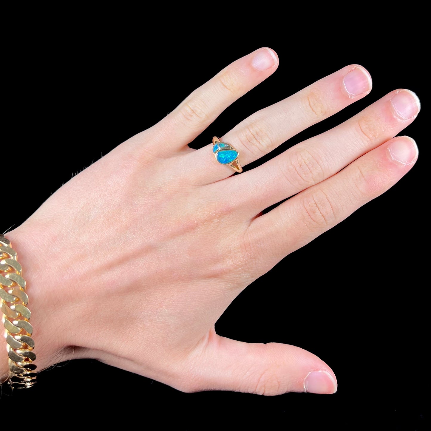 A ladies' black opal inlay ring cast in yellow gold.