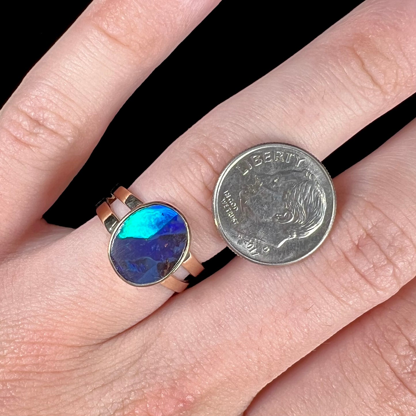 A ladies' split shank natural, Lightning Ridge, Australian black opal solitaire ring in yellow gold.