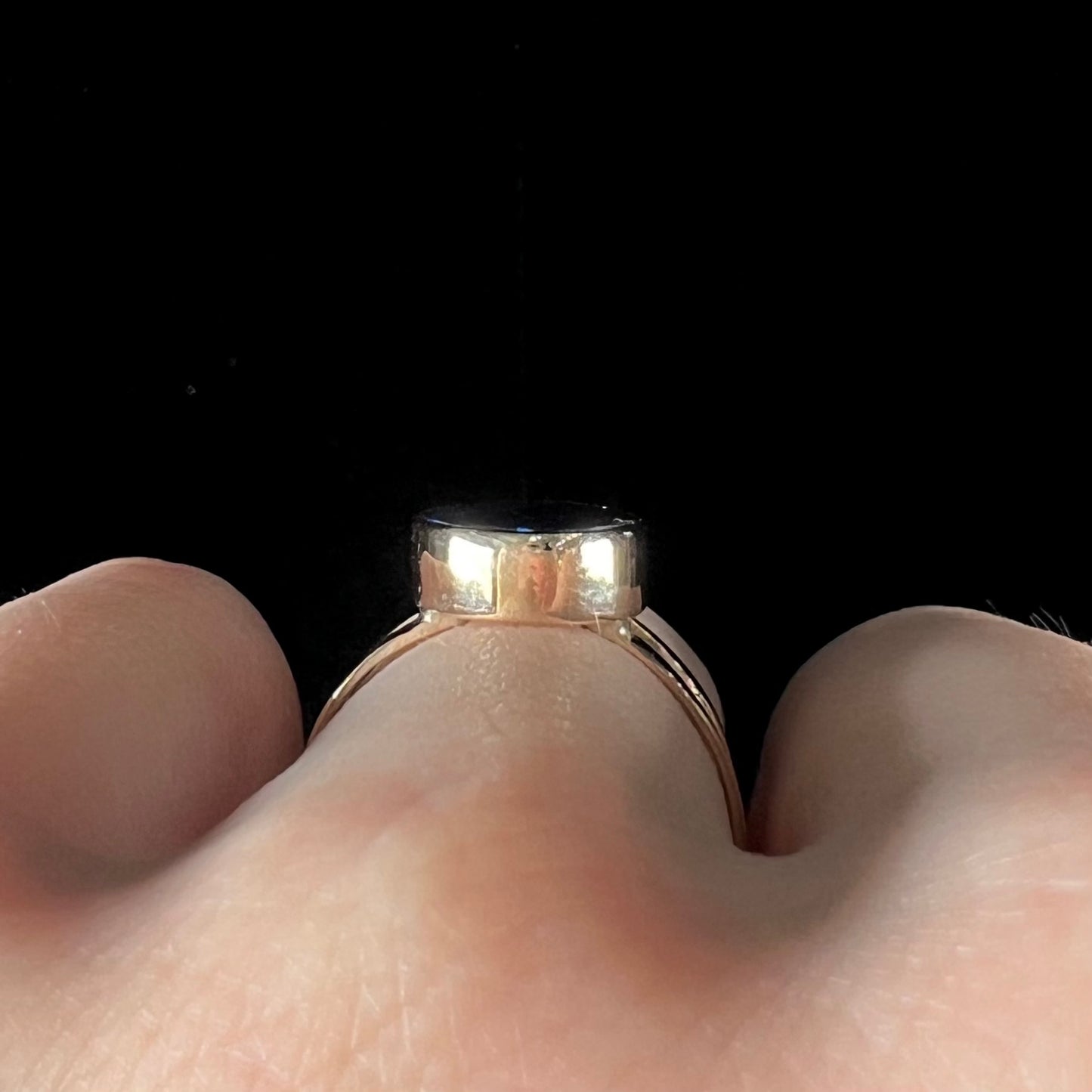 A ladies' split shank natural, Lightning Ridge, Australian black opal solitaire ring in yellow gold.