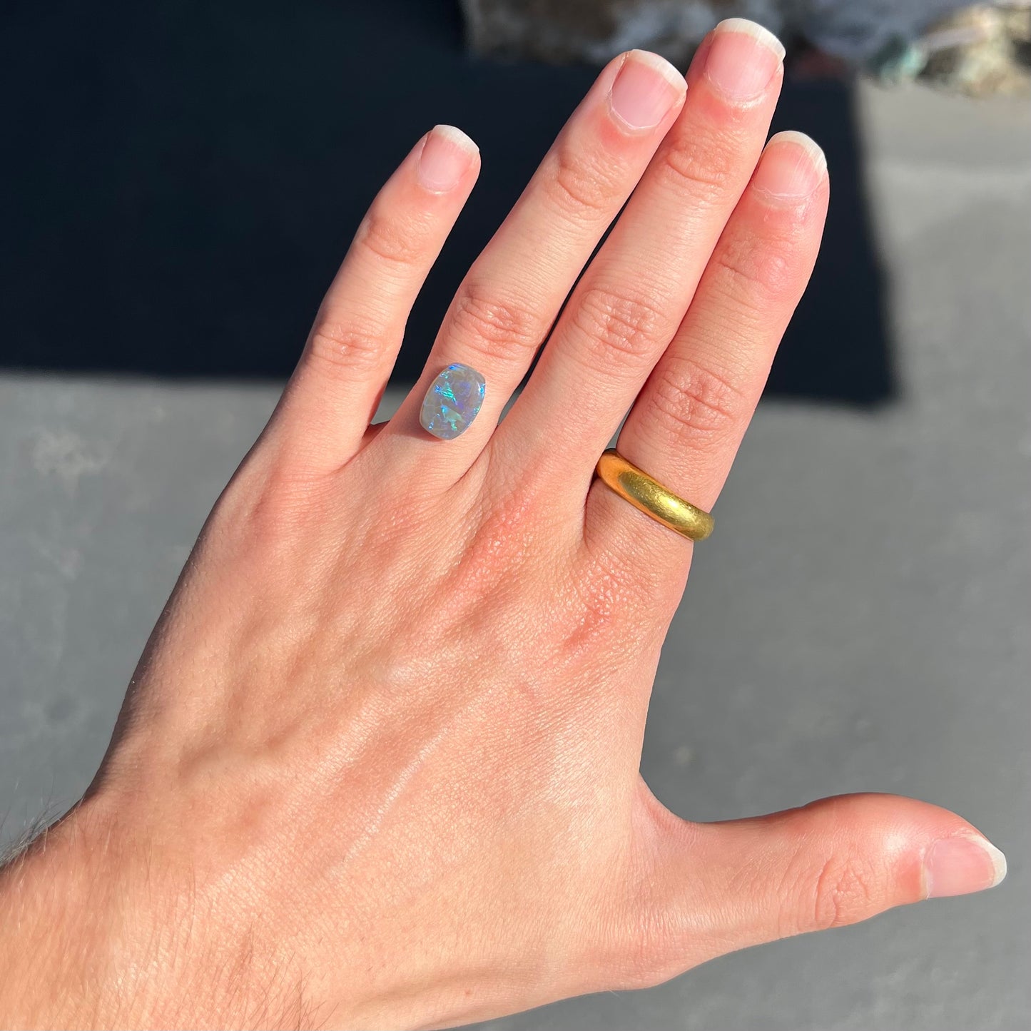 A loose, barrel shaped semi-black opal from Lightning Ridge, Australia. The opal has blue colors.
