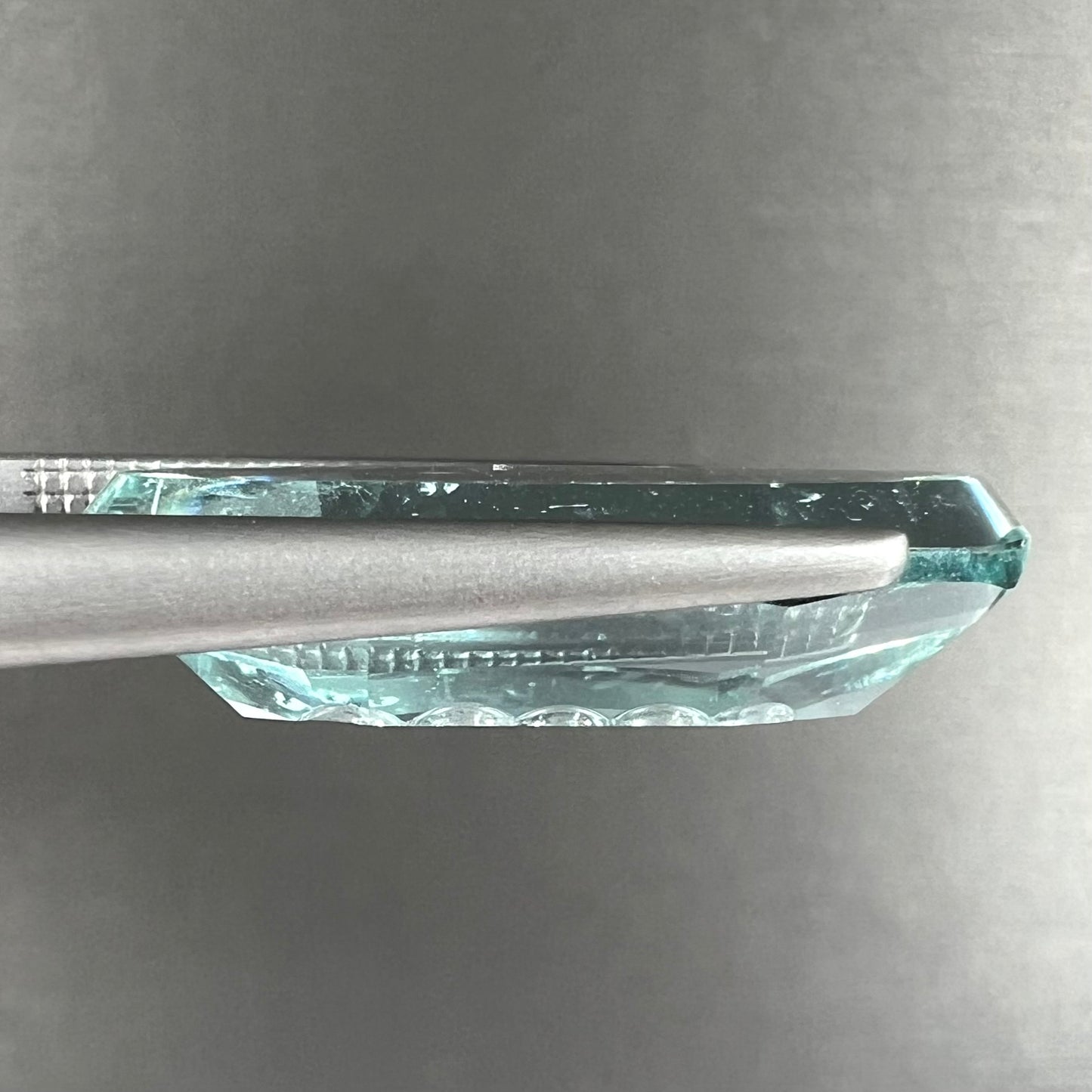 An oval fantasy cut greenish blue aquamarine stone cut by gem carver, Arthur Lee Anderson.