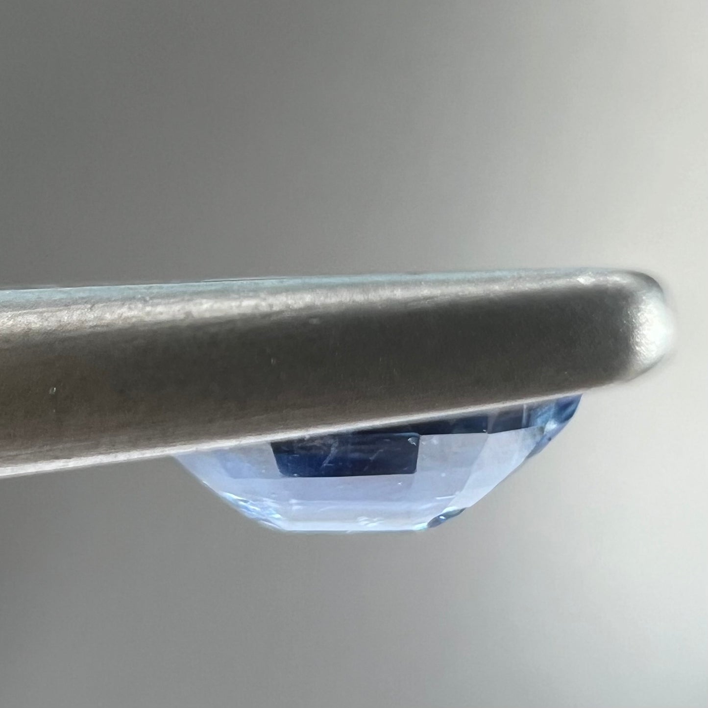 A loose, faceted oval cut blue kyanite gemstone.