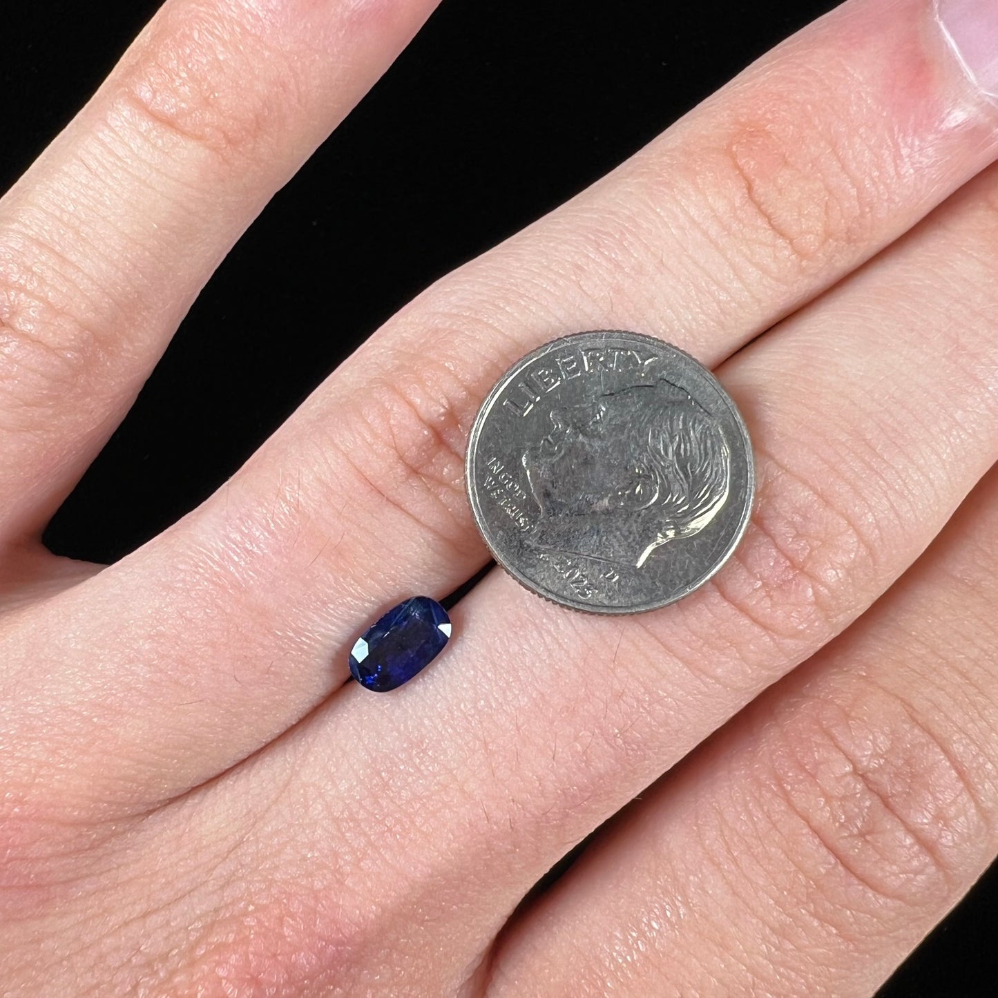 A loose, elongated oval cut blue sapphire gemstone.