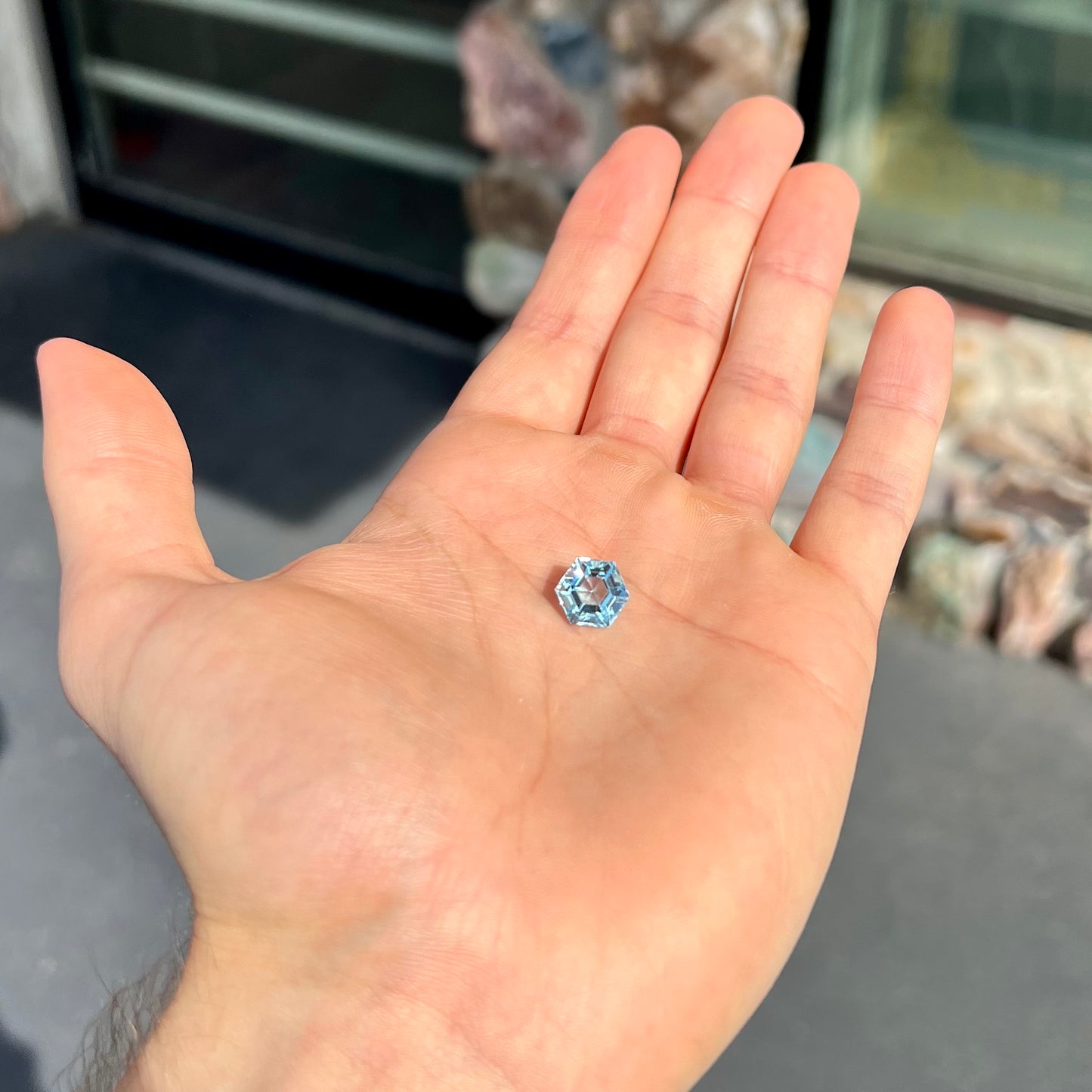 A faceted hexagon cut sky blue topaz gemstone.