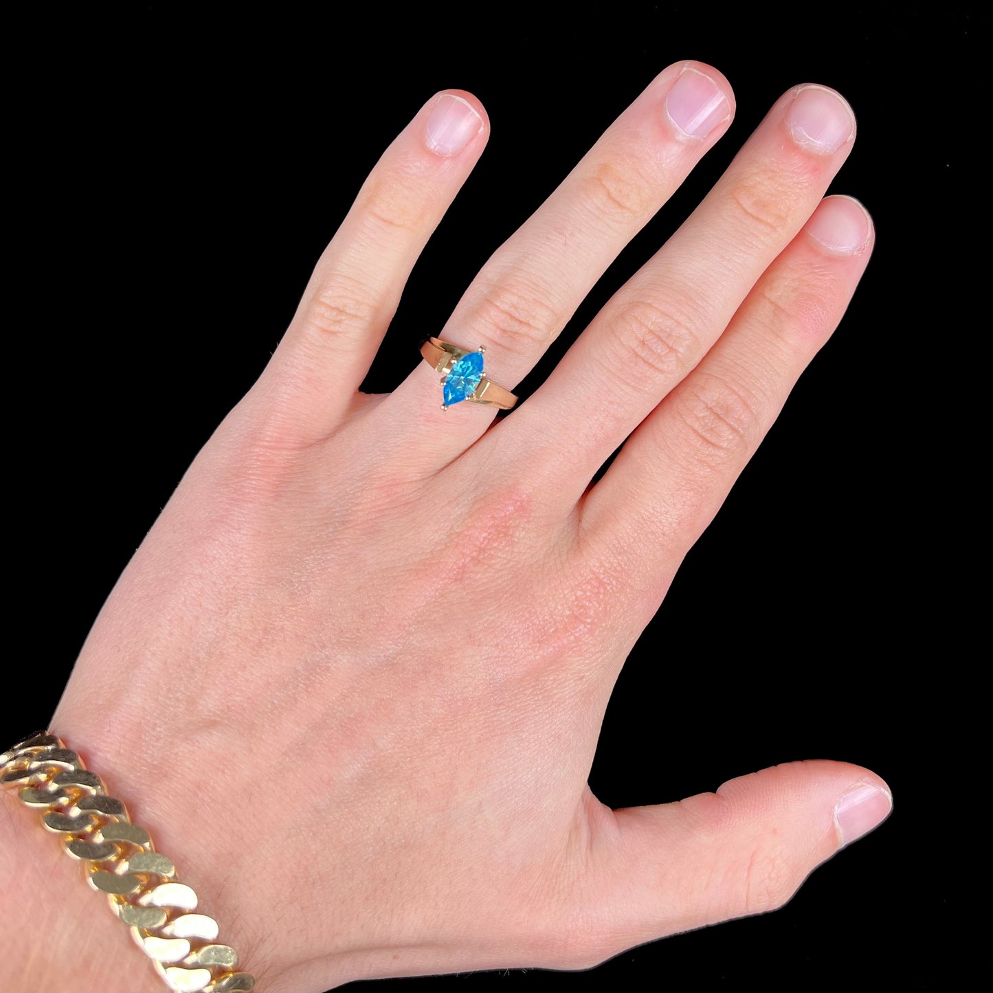A ladies' estate yellow gold ring, prong set with a marquise cut blue topaz stone. There are scratches on the shank.