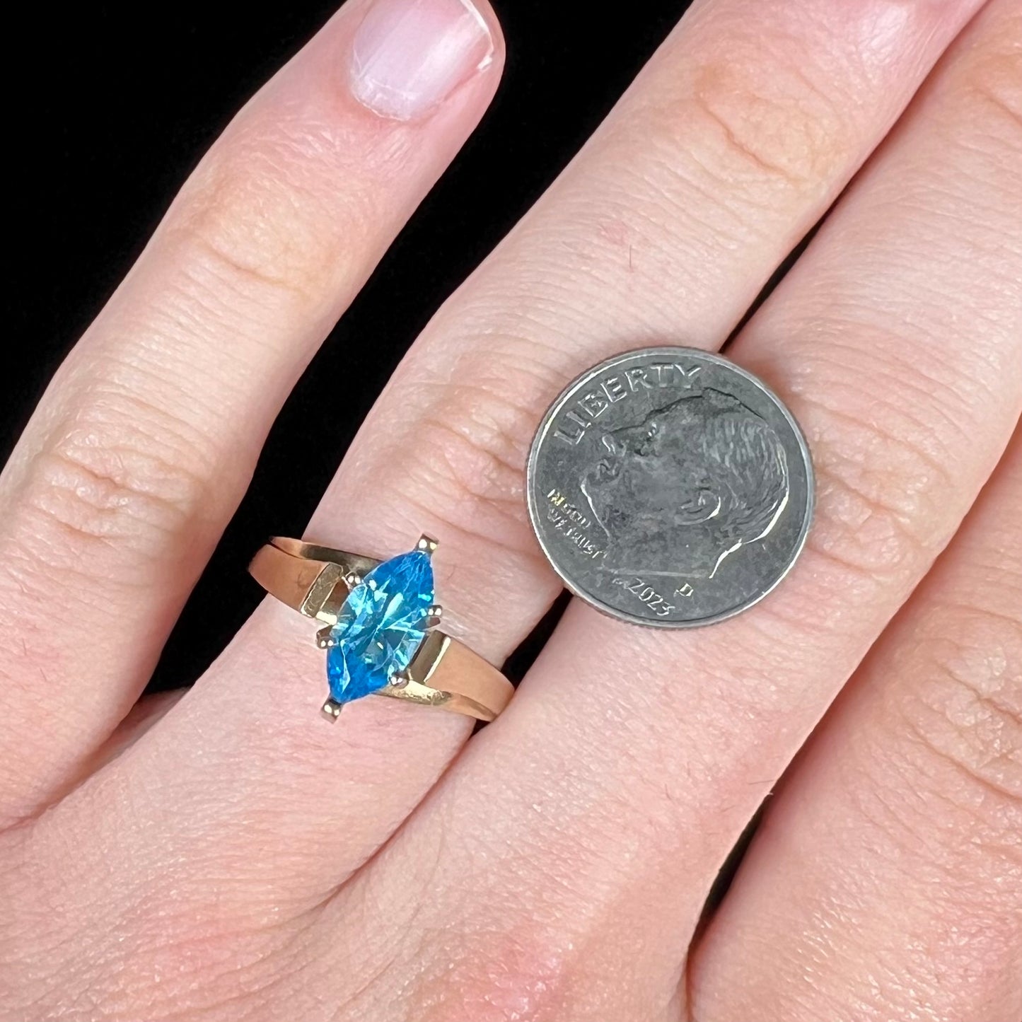 A ladies' estate yellow gold ring, prong set with a marquise cut blue topaz stone. There are scratches on the shank.