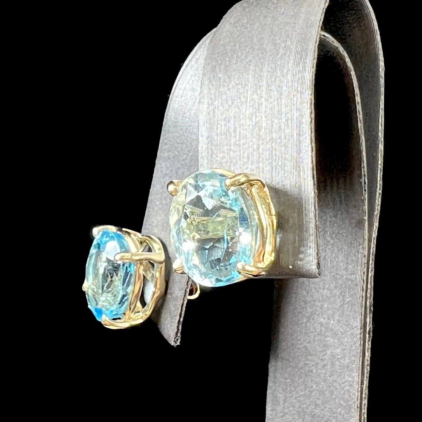 A pair of yellow gold push-back blue topaz stud earrings.