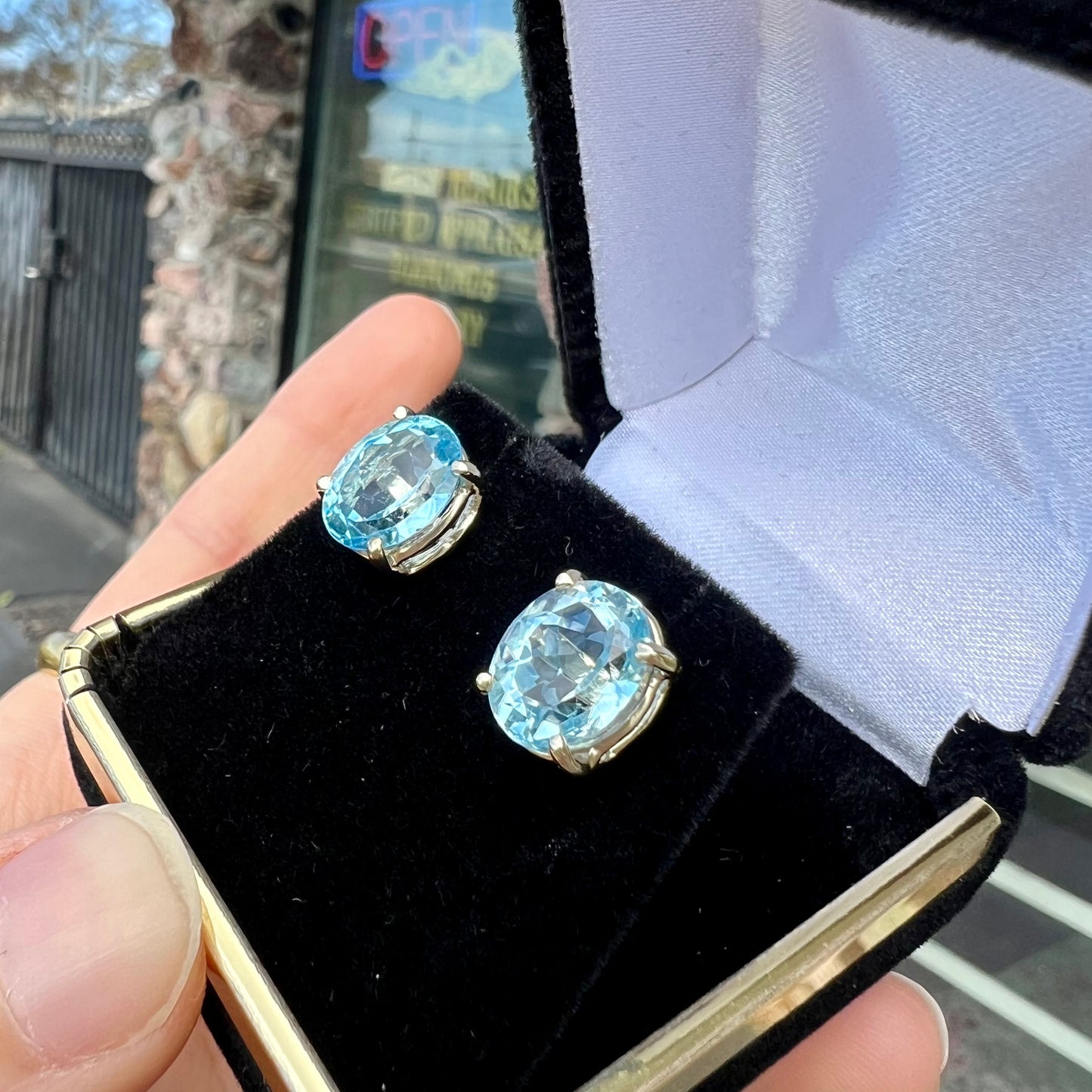 A pair of yellow gold push-back blue topaz stud earrings.