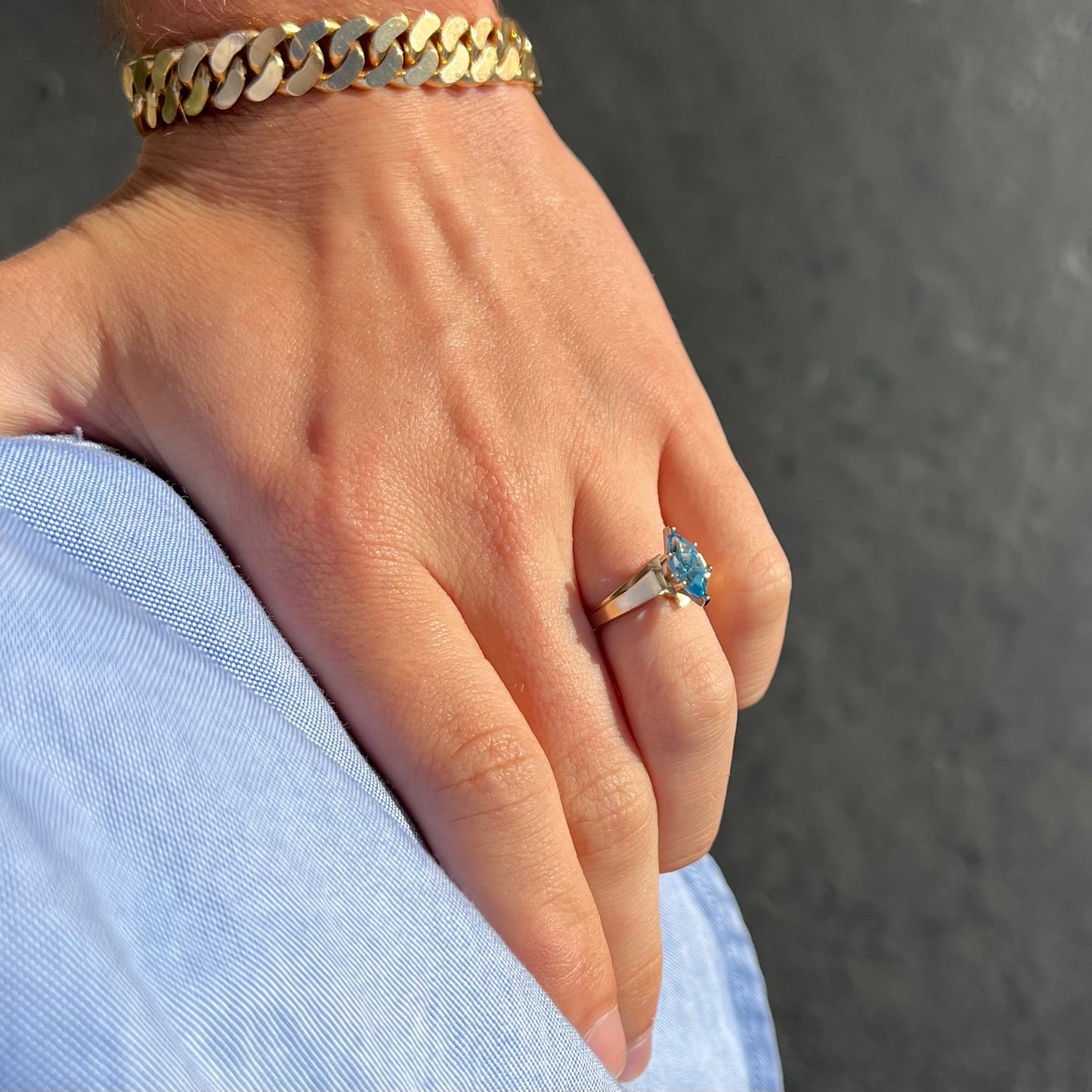 A ladies' estate yellow gold ring, prong set with a marquise cut blue topaz stone. There are scratches on the shank.