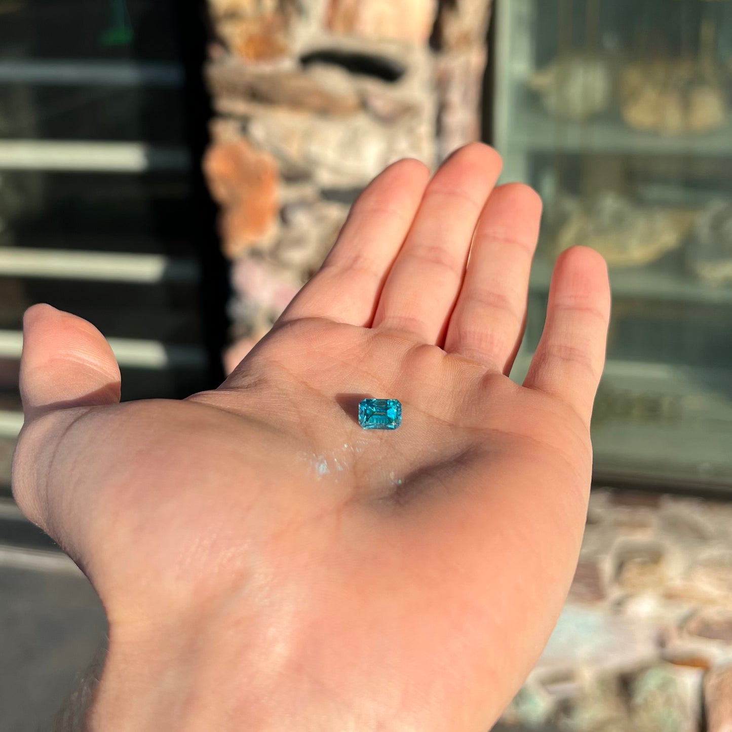 A natural blue zircon gemstone. The stone is emerald cut.