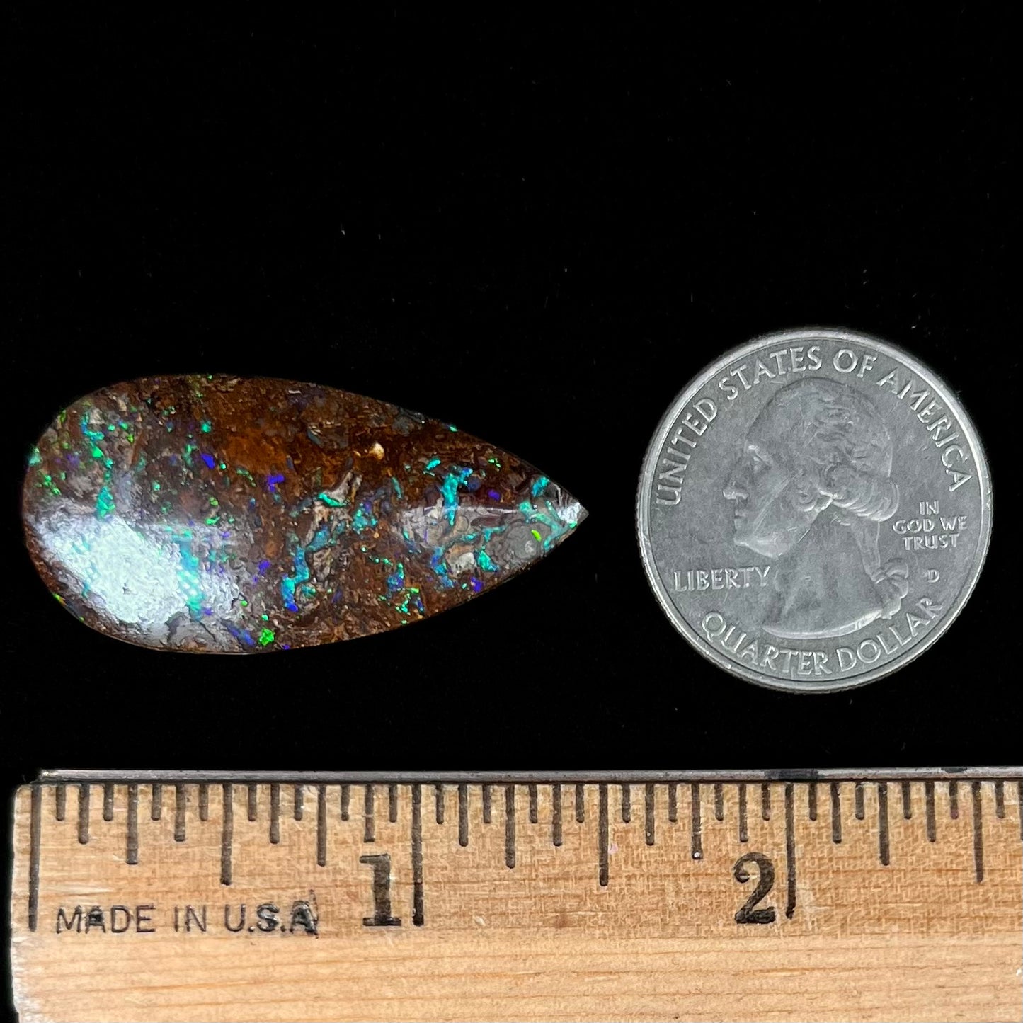 A pear shaped boulder opal stone from Koroit, Australia. The opal has blue and green flashes.