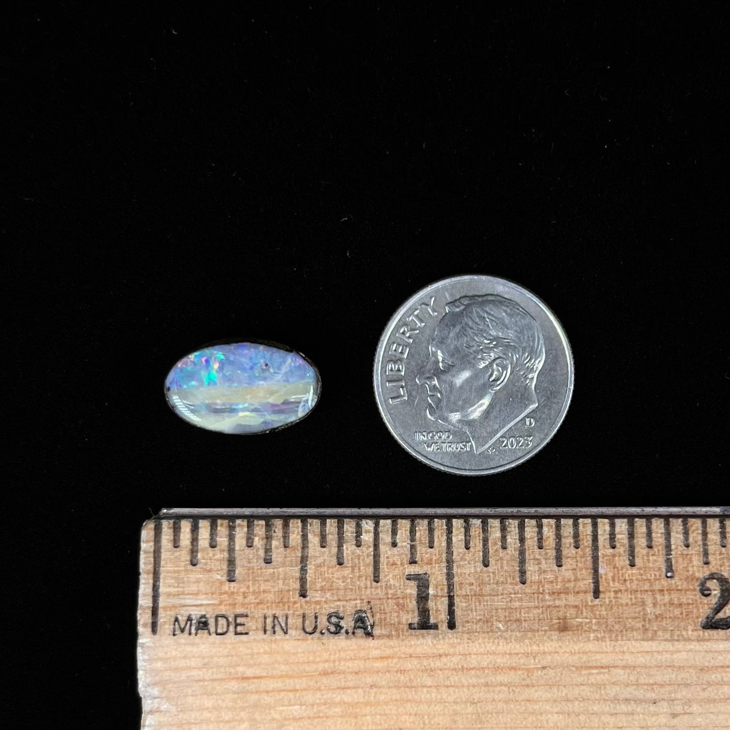 An oval cabochon cut boulder opal from Quilpie, Australia. The opal has multicolor color play.