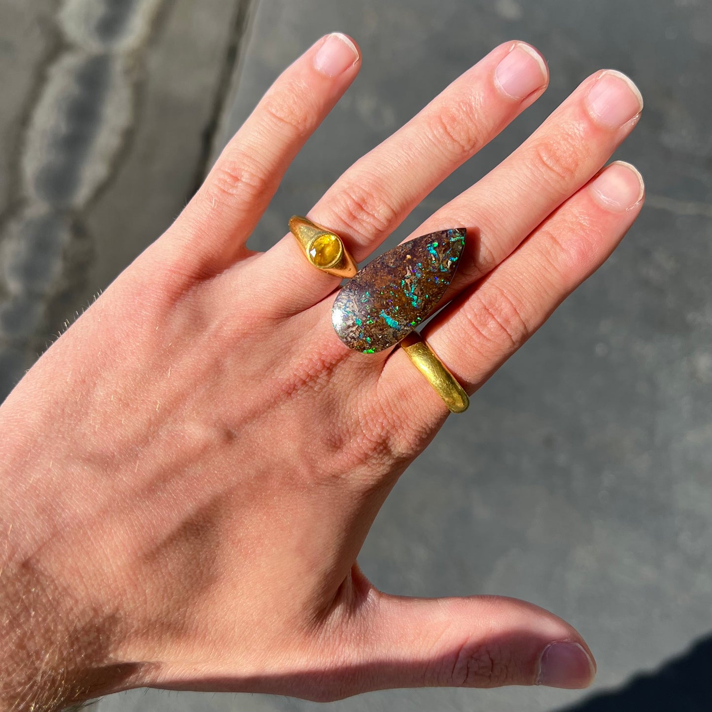 A pear shaped boulder opal stone from Koroit, Australia. The opal has blue and green flashes.