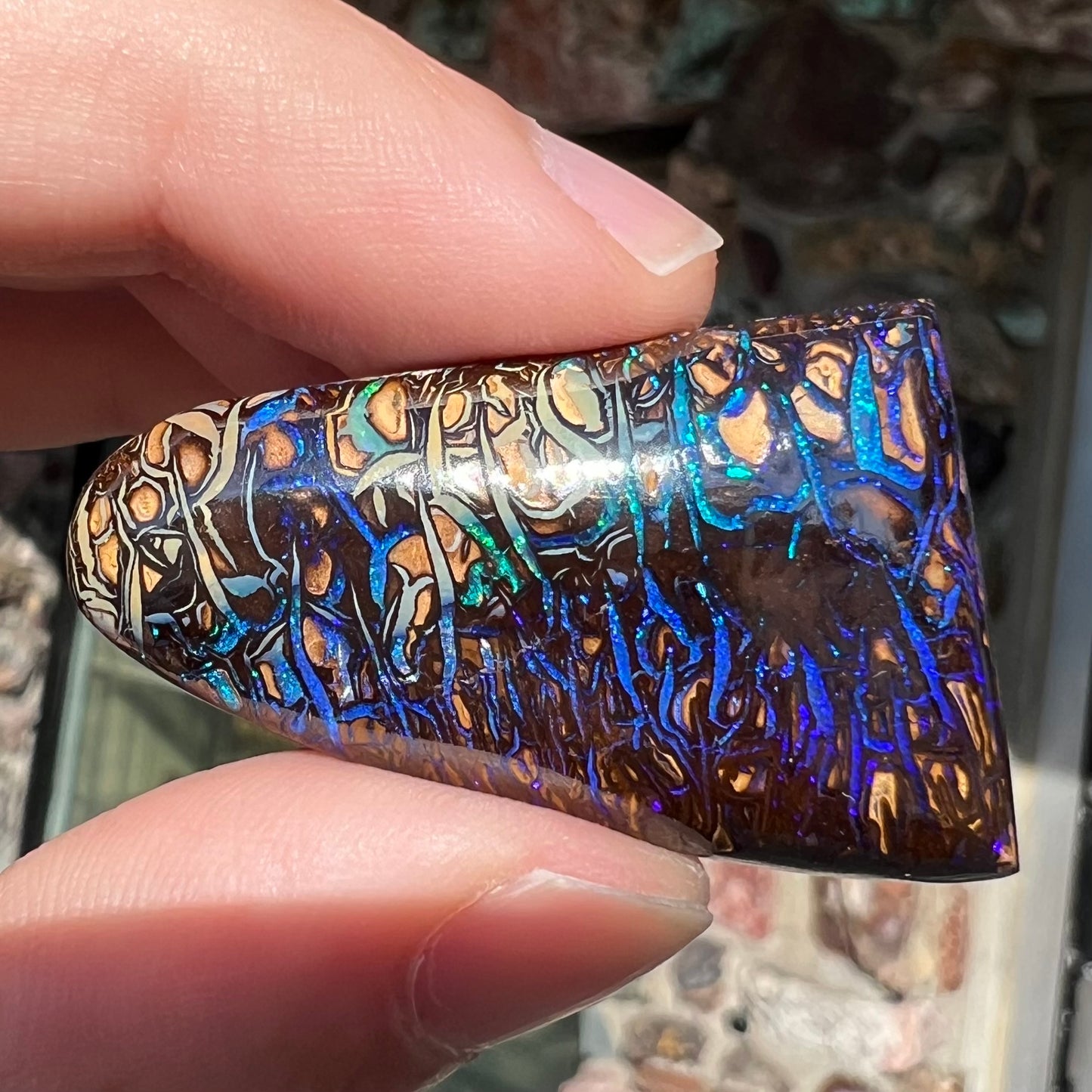 A loose boulder opal stone from Koroit, Australia. The opal has a blue and purple pattern.