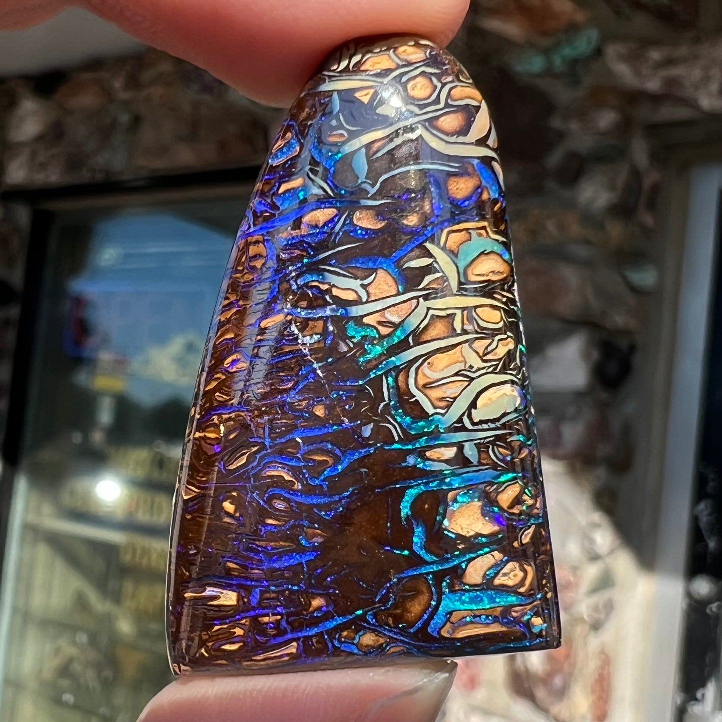 A loose boulder opal stone from Koroit, Australia. The opal has a blue and purple pattern.