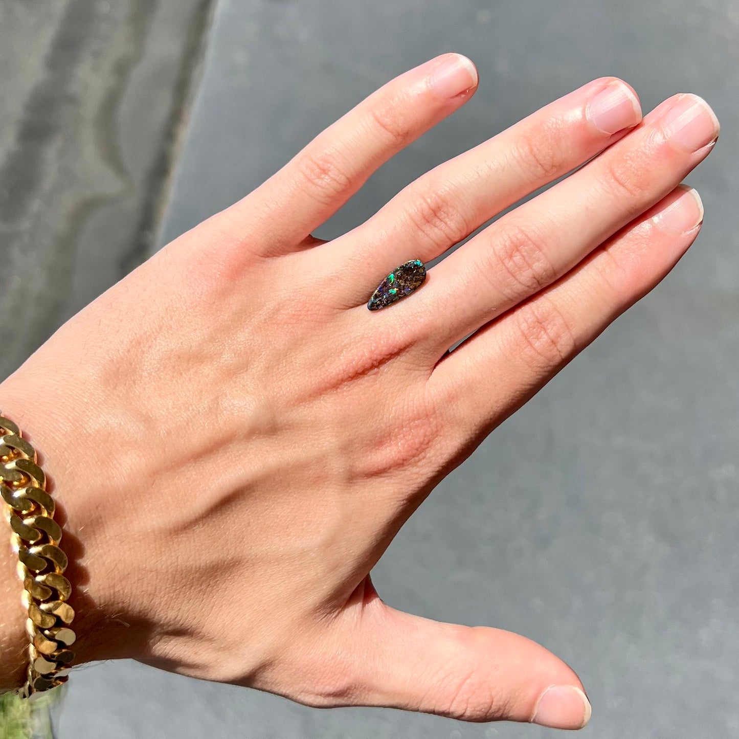 A loose, pear shaped boulder opal stone from Quilpie, Australia. The opal shines every color of the rainbow.