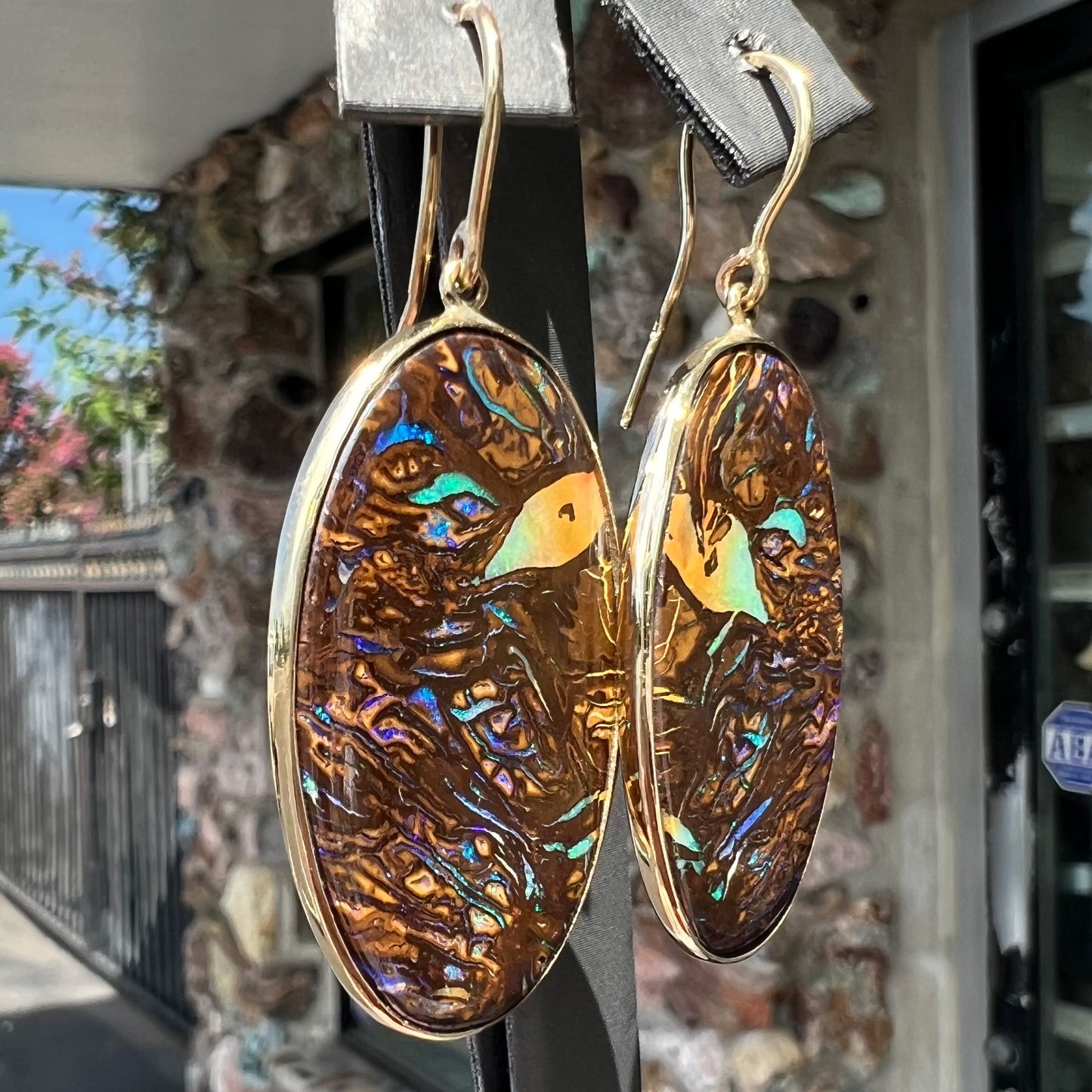 A pair of Koroit boulder opal dangle earrings set in yellow gold bezels.