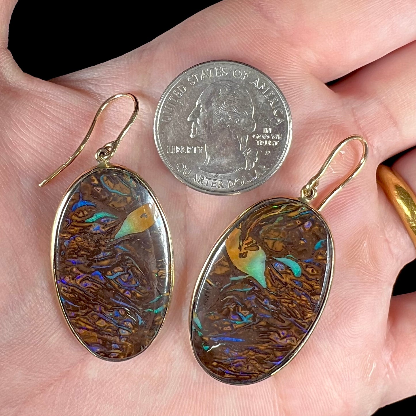 A pair of Koroit boulder opal dangle earrings set in yellow gold bezels.