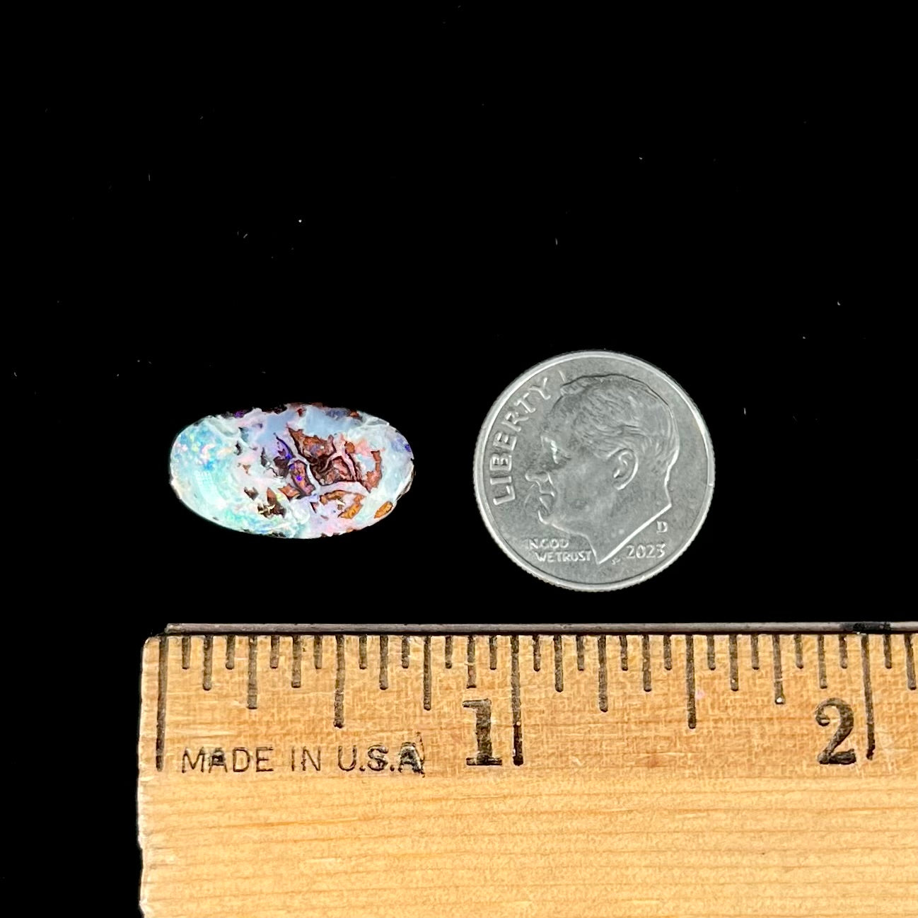 An oval cabochon cut boulder opal stone from Koroit, Australia. The opal has a white body tone.