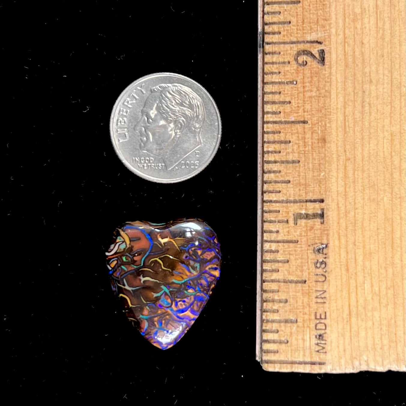 A heart shaped boulder opal stone with purple veins.