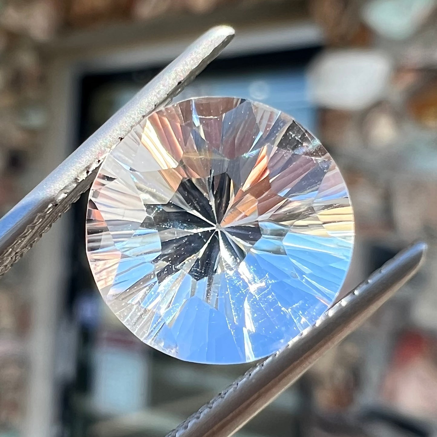 A round brilliant cut petalite gemstone. The stone is colorless.