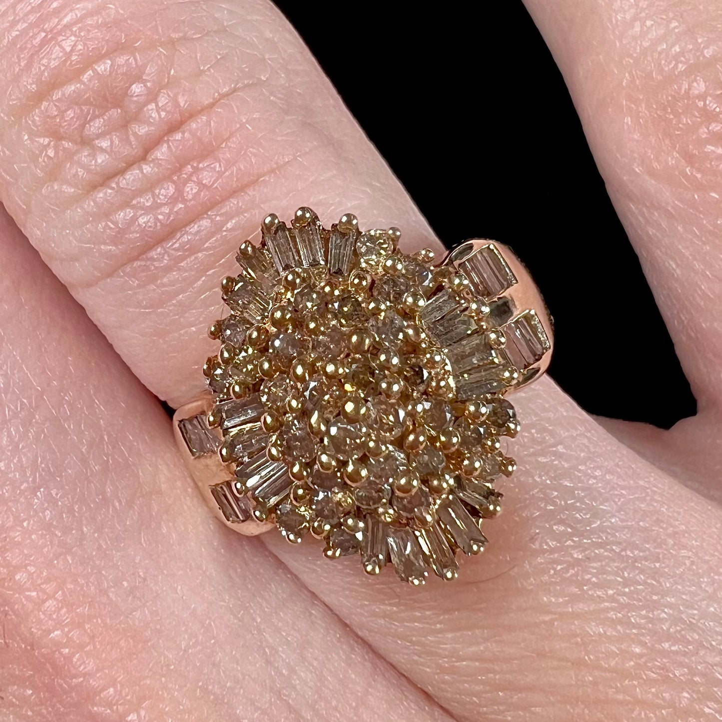 A ladies' cluster ring set with round and baguette cut cognac brown diamonds.