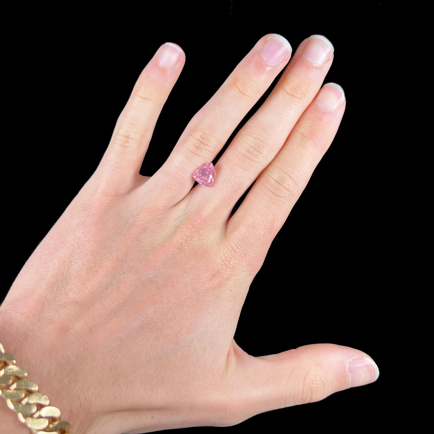 A loose, faceted trillion cut pink touramline gemstone.  The stone is a light bubblegum pink color.