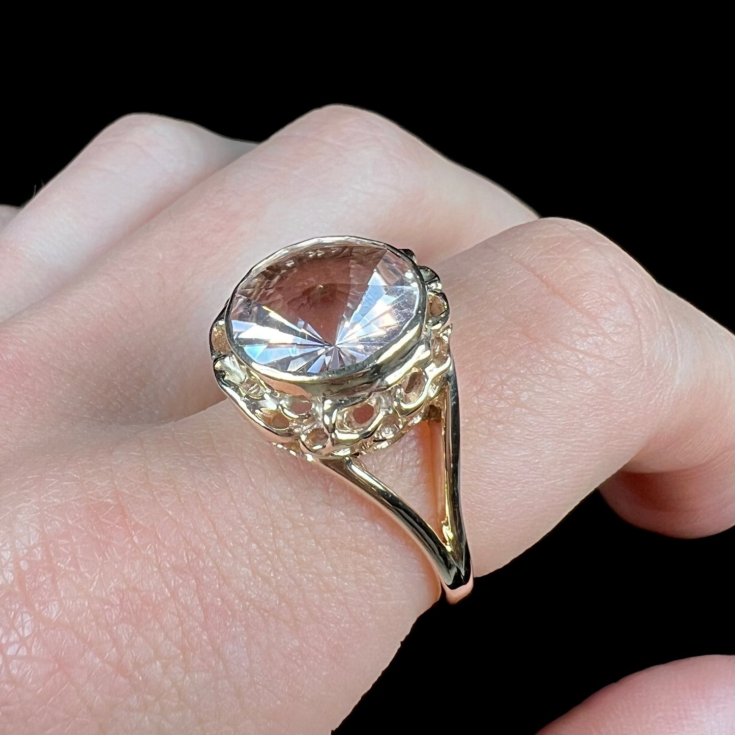 A ladies' yellow gold solitaire ring bezel set with a modified bud cut morganite gemstone.