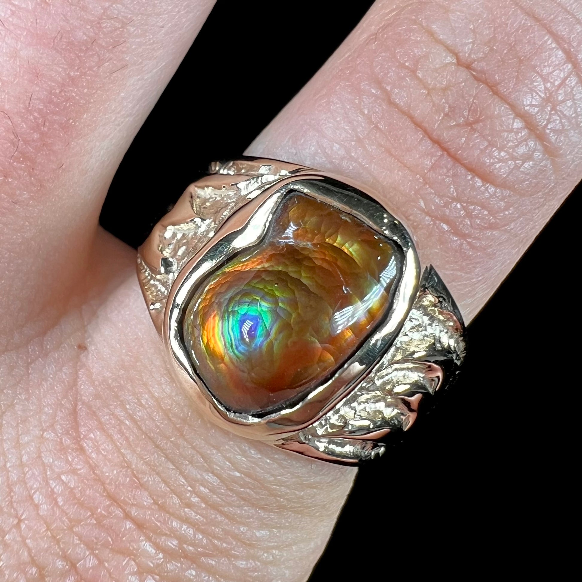 A man's yellow gold solitaire ring set with a freeform shaped Mexican fire agate stone.  The stone has a purple bull's eye pattern.