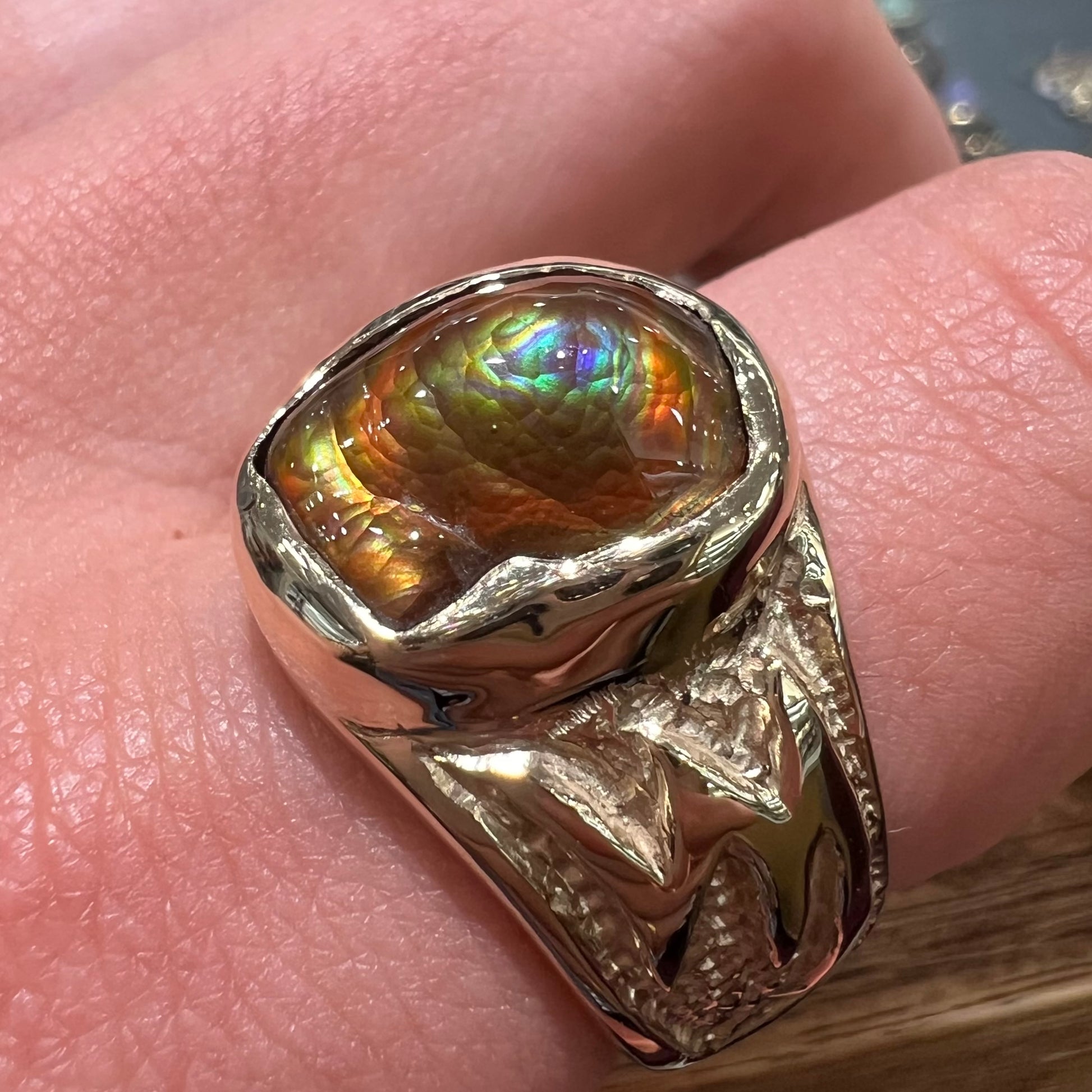 A man's yellow gold solitaire ring set with a freeform shaped Mexican fire agate stone.  The stone has a purple bull's eye pattern.