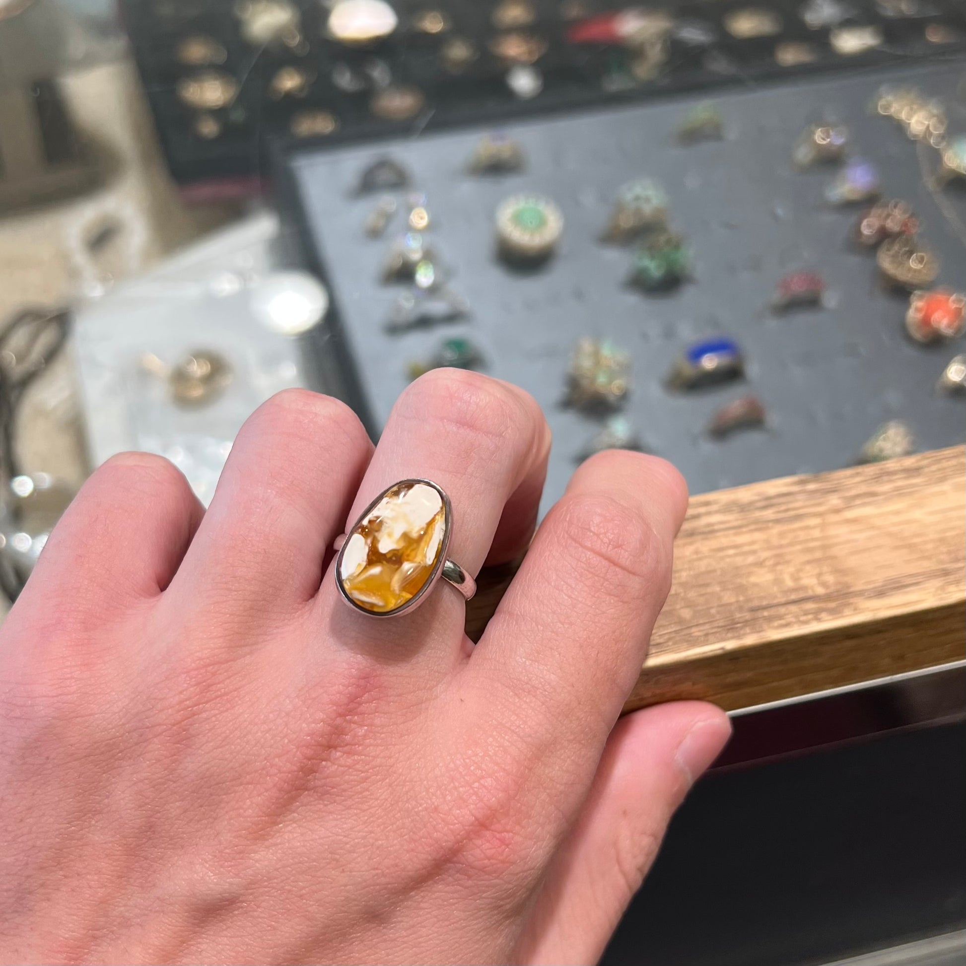 An adjustable sterling silver solitaire ring set with a cabochon cut butterscotch amber stone.