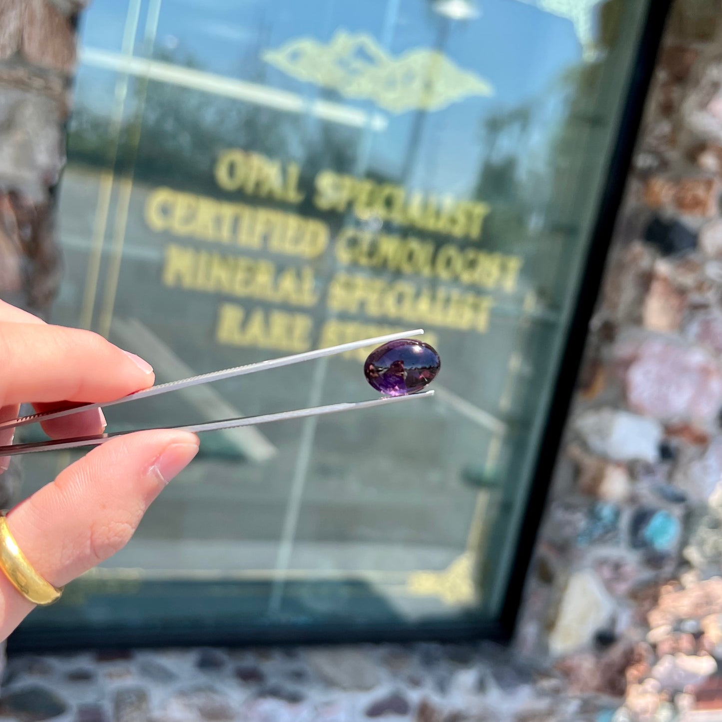 A loose, oval buff top cut amethyst gemstone. The top of the stone is domed, and the bottom is faceted.