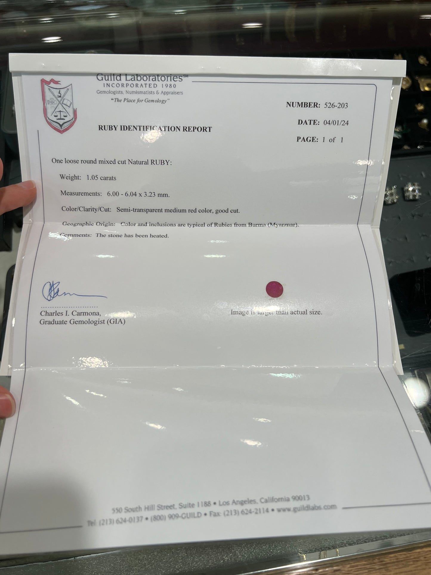 A faceted round brilliant cut Burma ruby gemstone. The stone is certified as natural by Guild Laboratories.