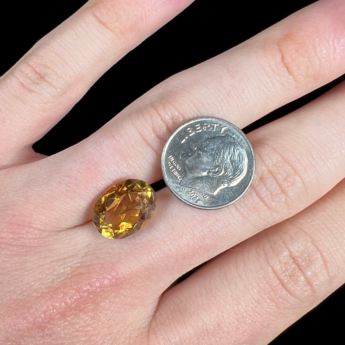 A loose, oval cut citrine gemstone. The stone is heavily included and roughly cut.