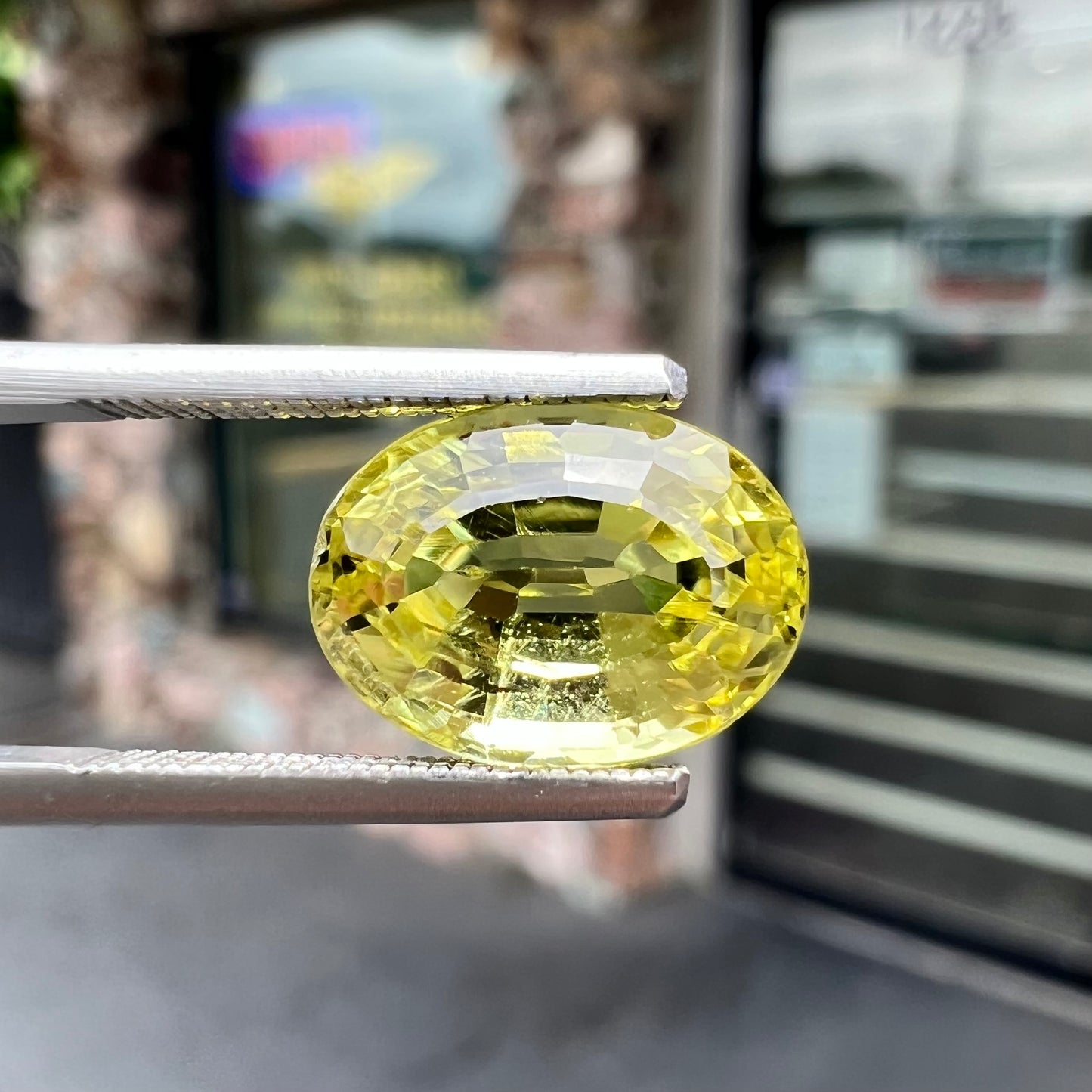 A loose, oval cut greenish yellow chrysoberyl stone.