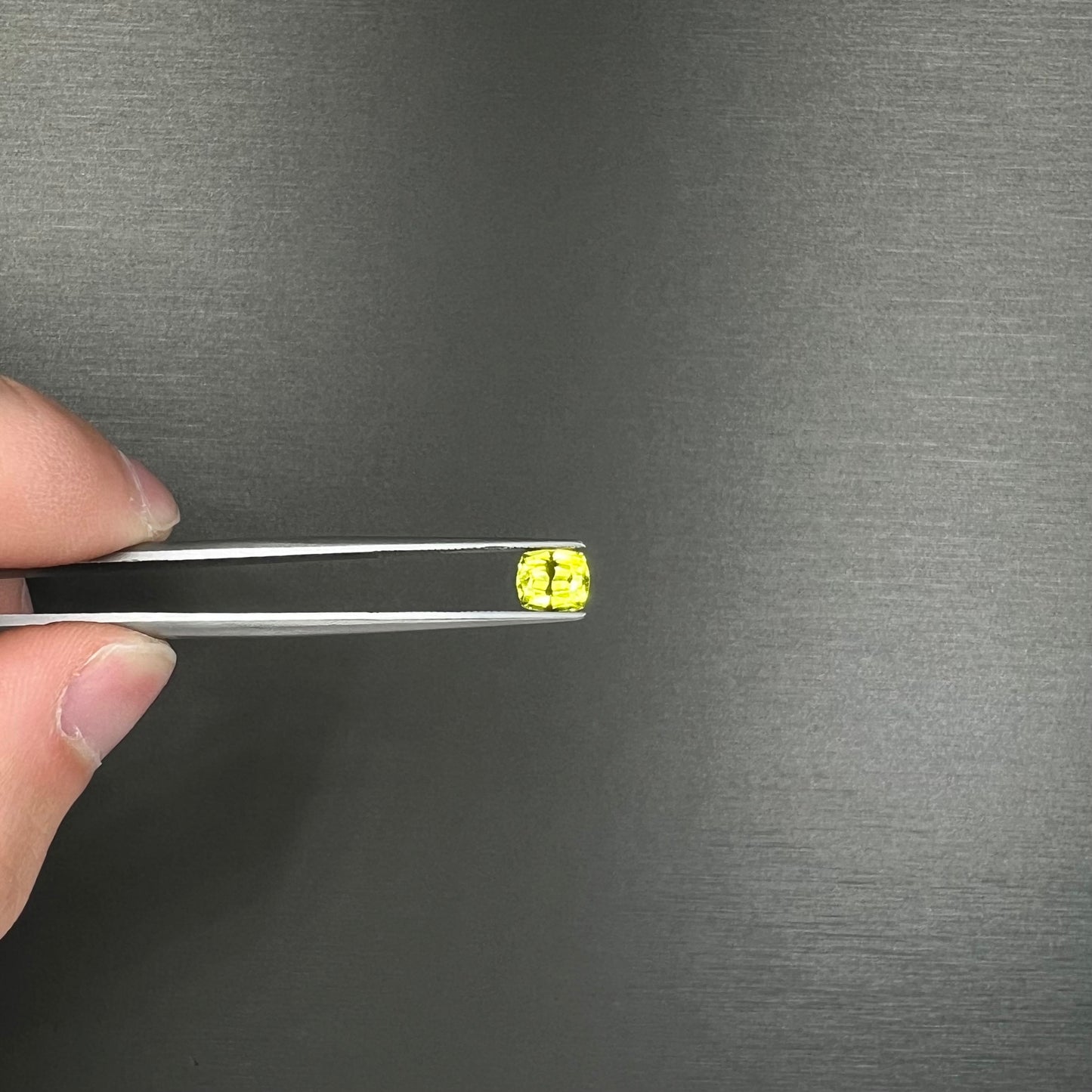 A loose, modified cushion cut greenish yellow chrysoberyl gemstone.