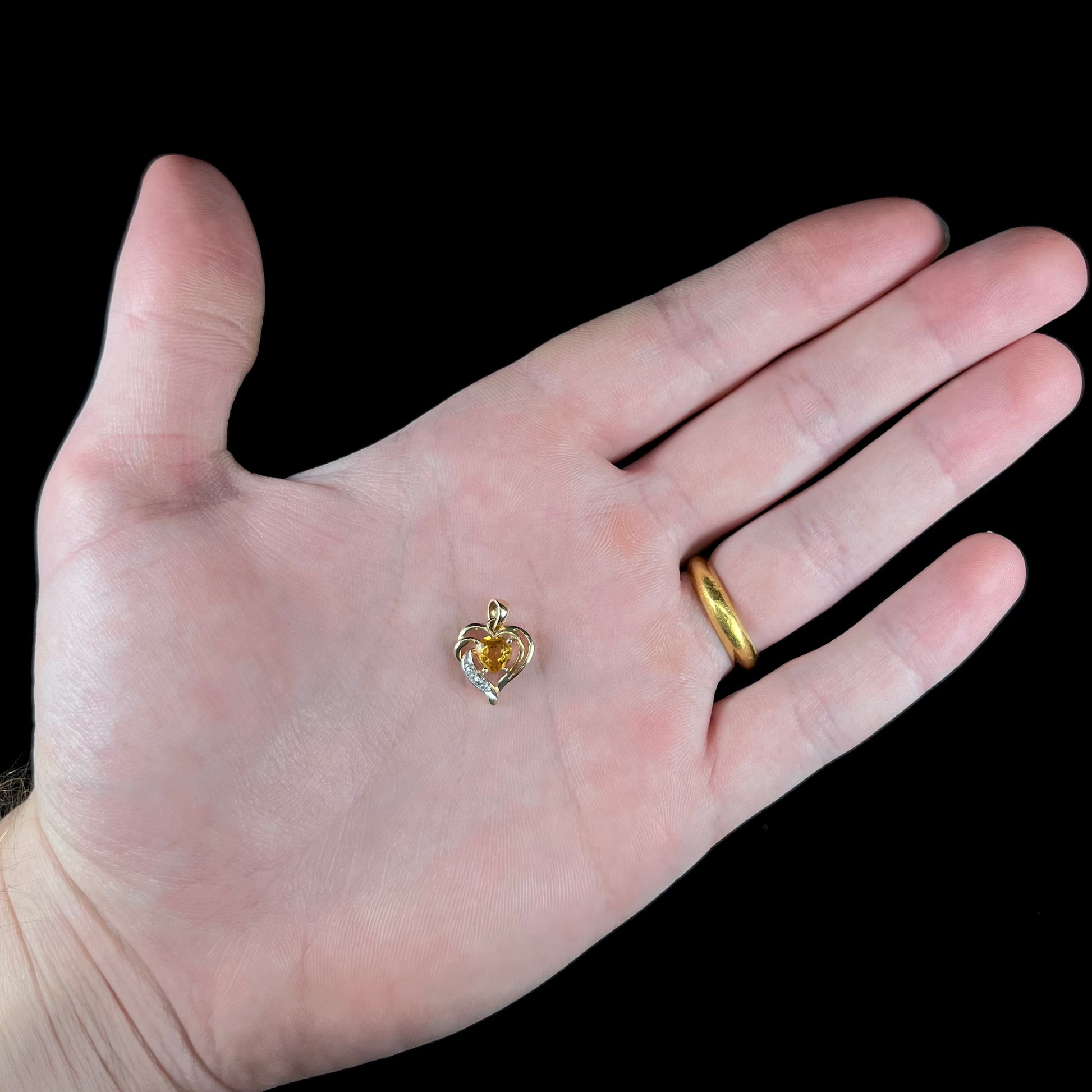 A ladies' yellow gold pendant set with a heart cut citrine stone and a diamond accent.