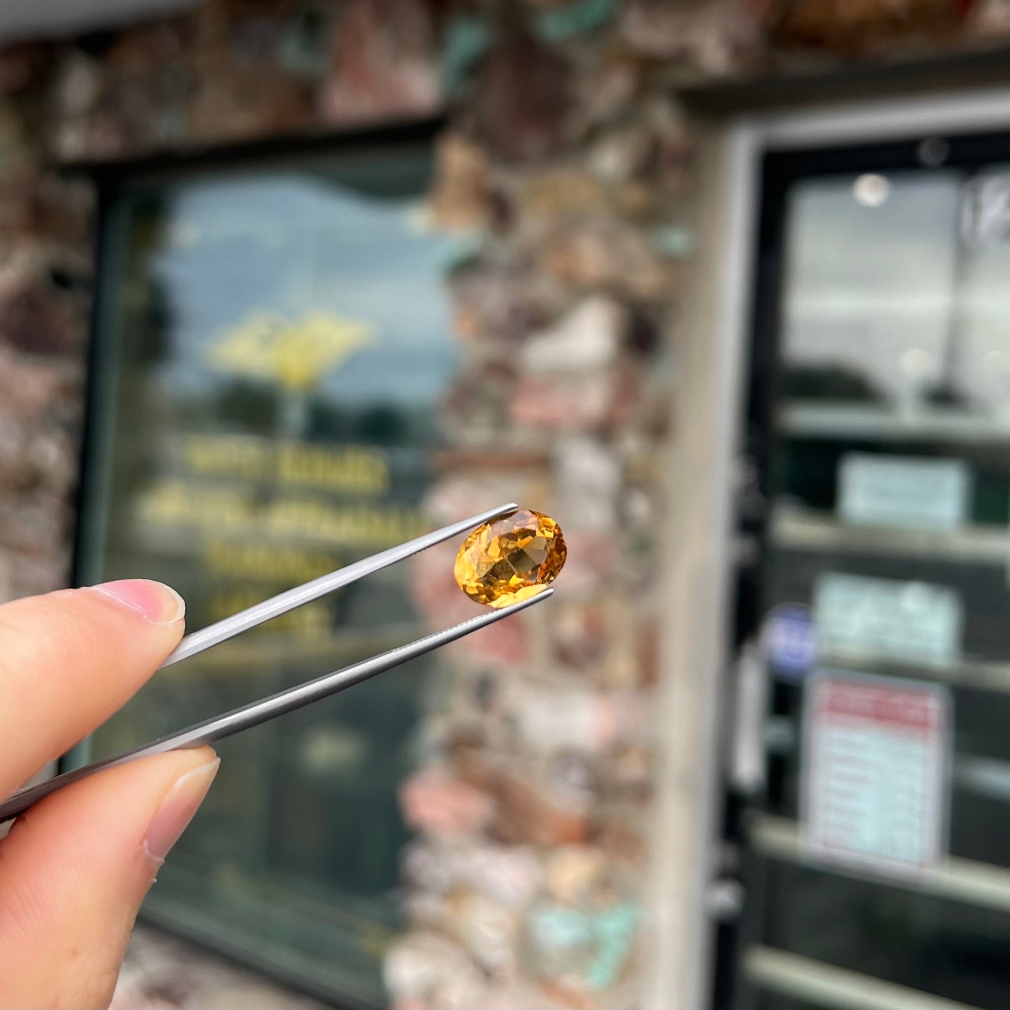 A loose, oval cut citrine gemstone. The stone is heavily included and roughly cut.