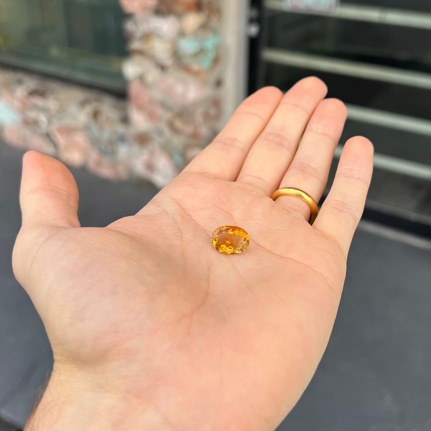A loose, oval cut citrine gemstone. The stone is heavily included and roughly cut.