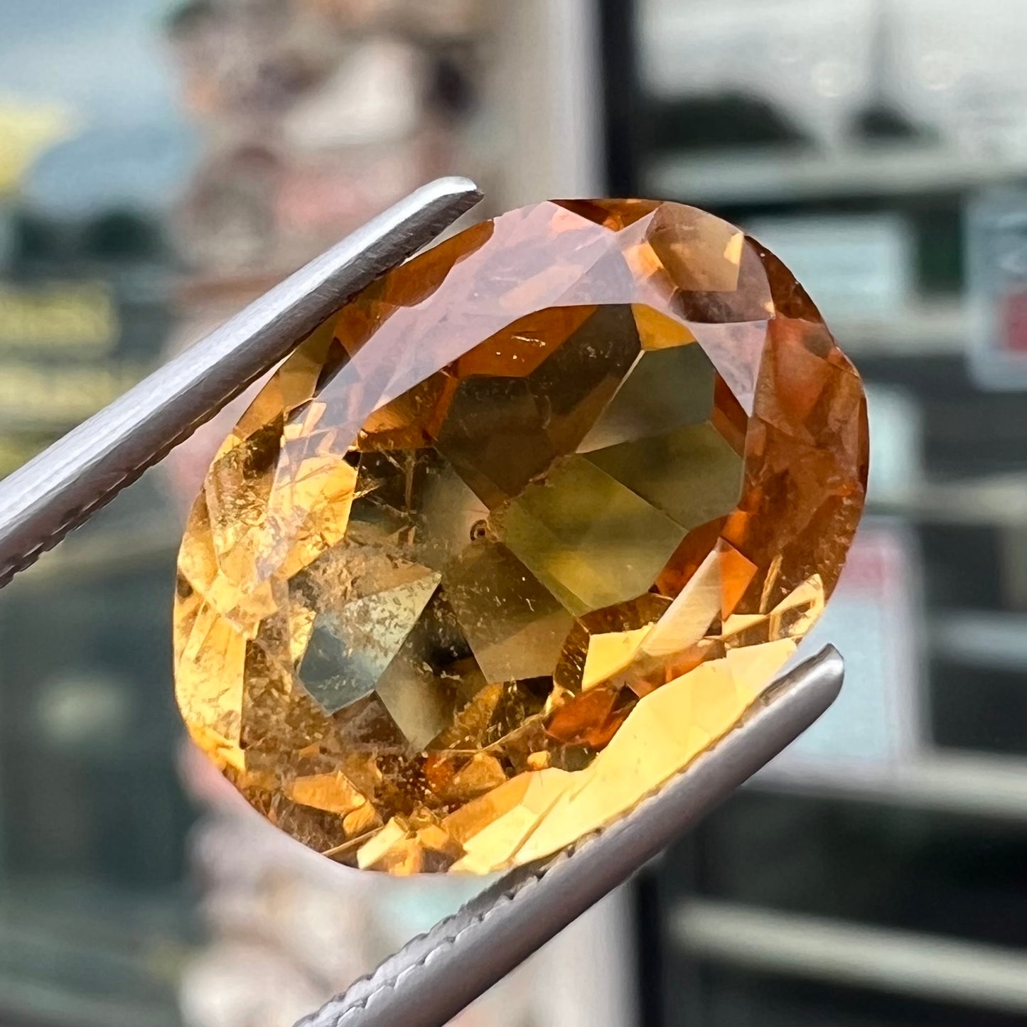 A loose, oval cut citrine gemstone. The stone is heavily included and roughly cut.