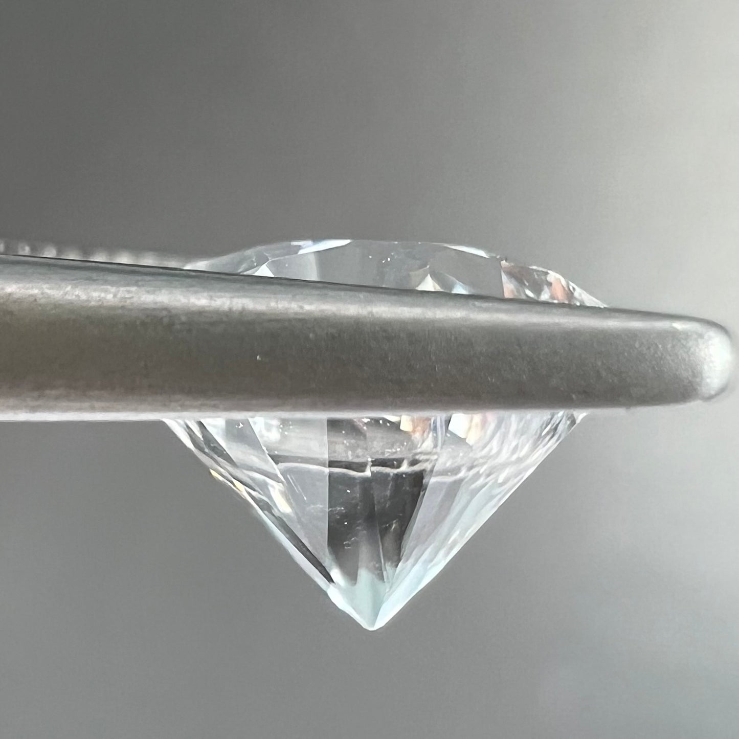 A round brilliant cut petalite gemstone. The stone is colorless.