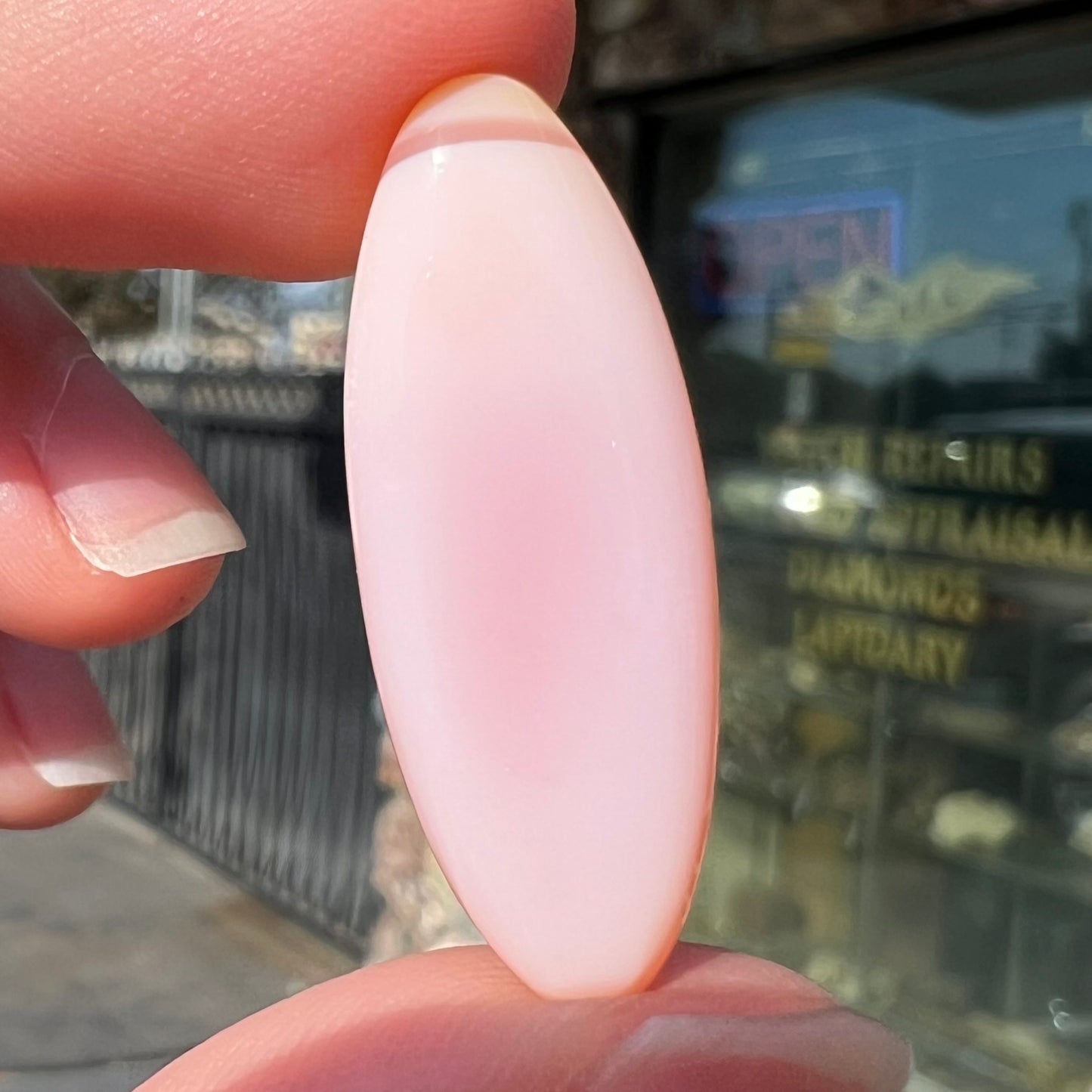 A loose, marquise cabochon cut pink common opal from Peru. The opal has no play of color.