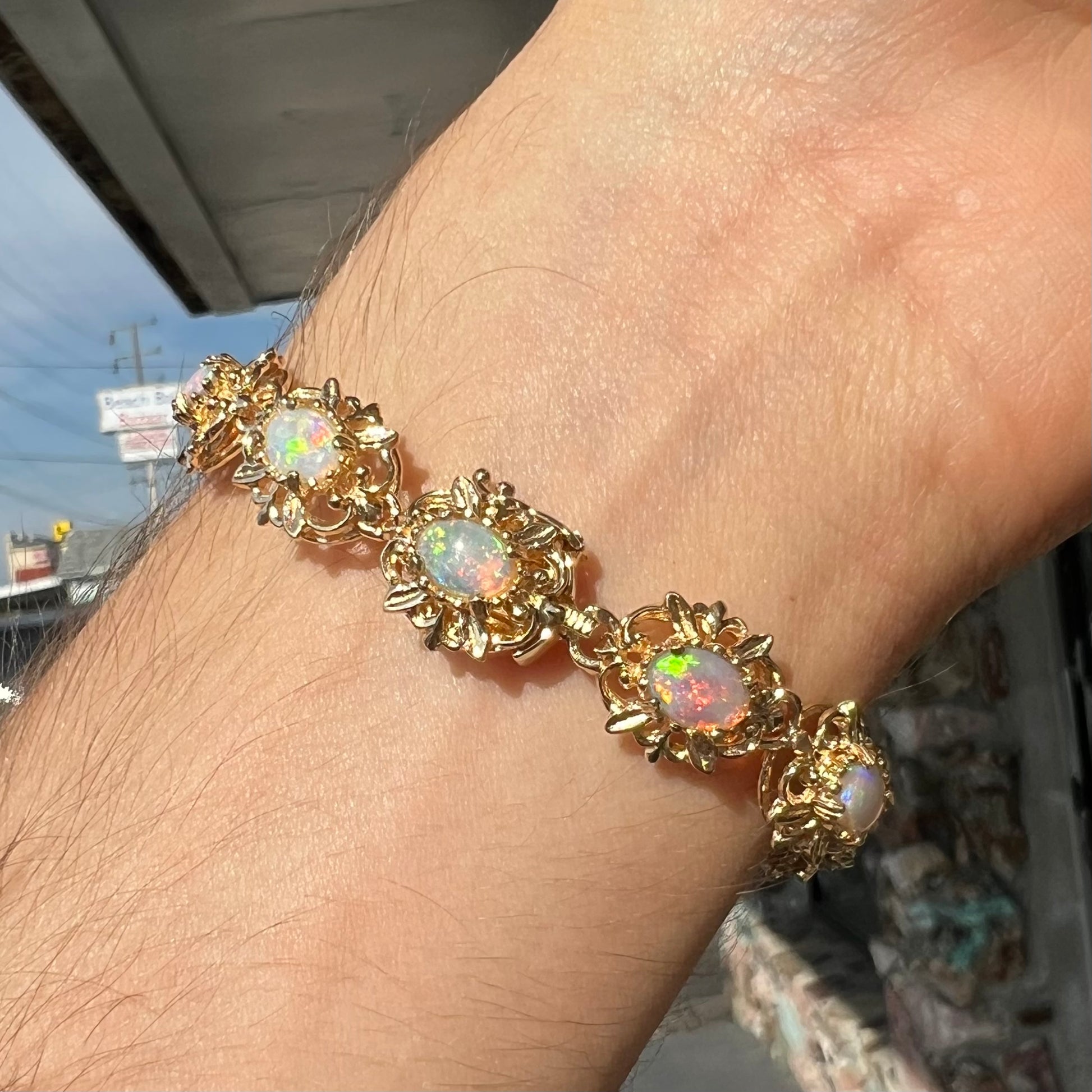 A ladies' yellow gold bracelet set with natural, oval cabochon cut white crystal opals.