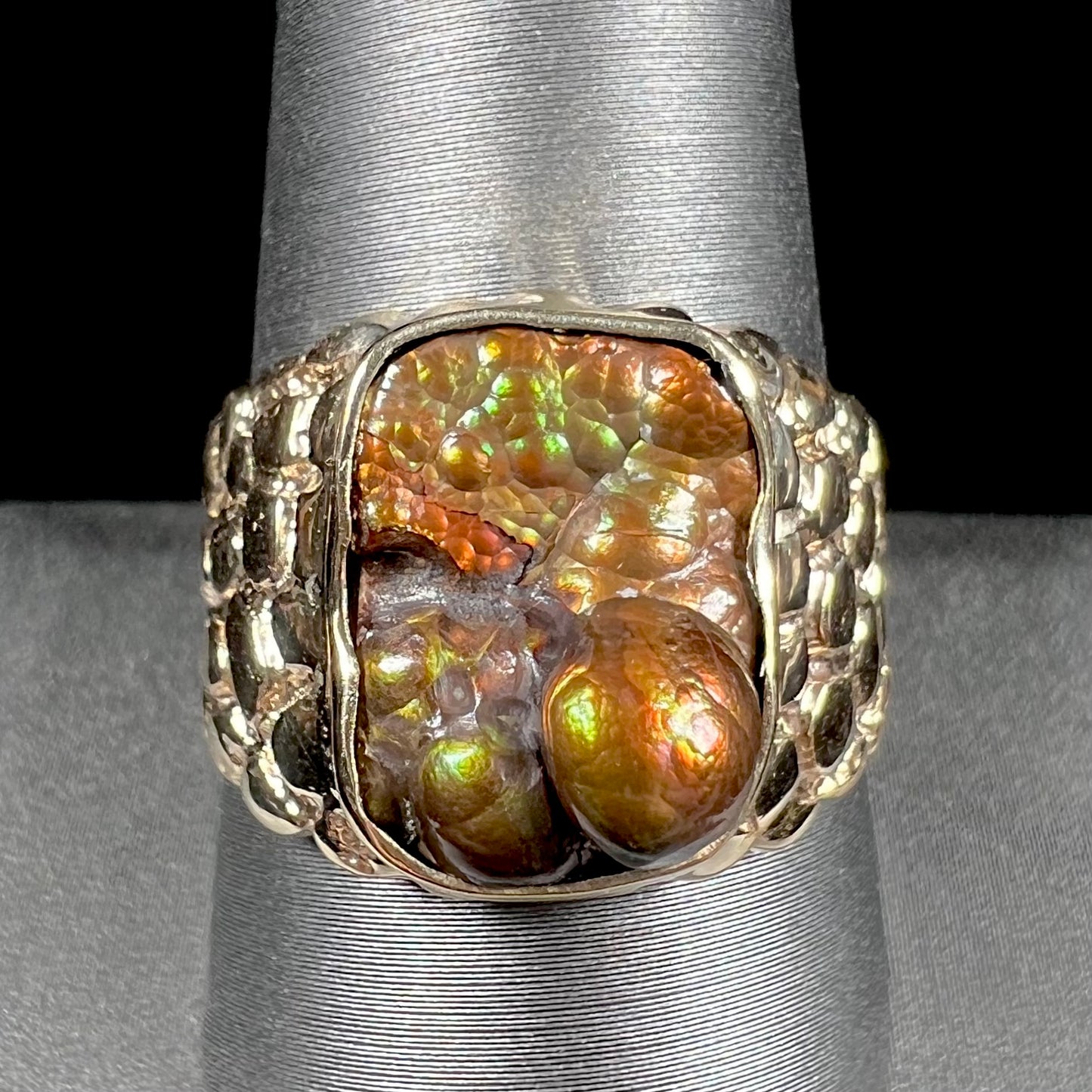 A men's yellow gold, nugget style ring set with a bubbly, California fire agate stone.