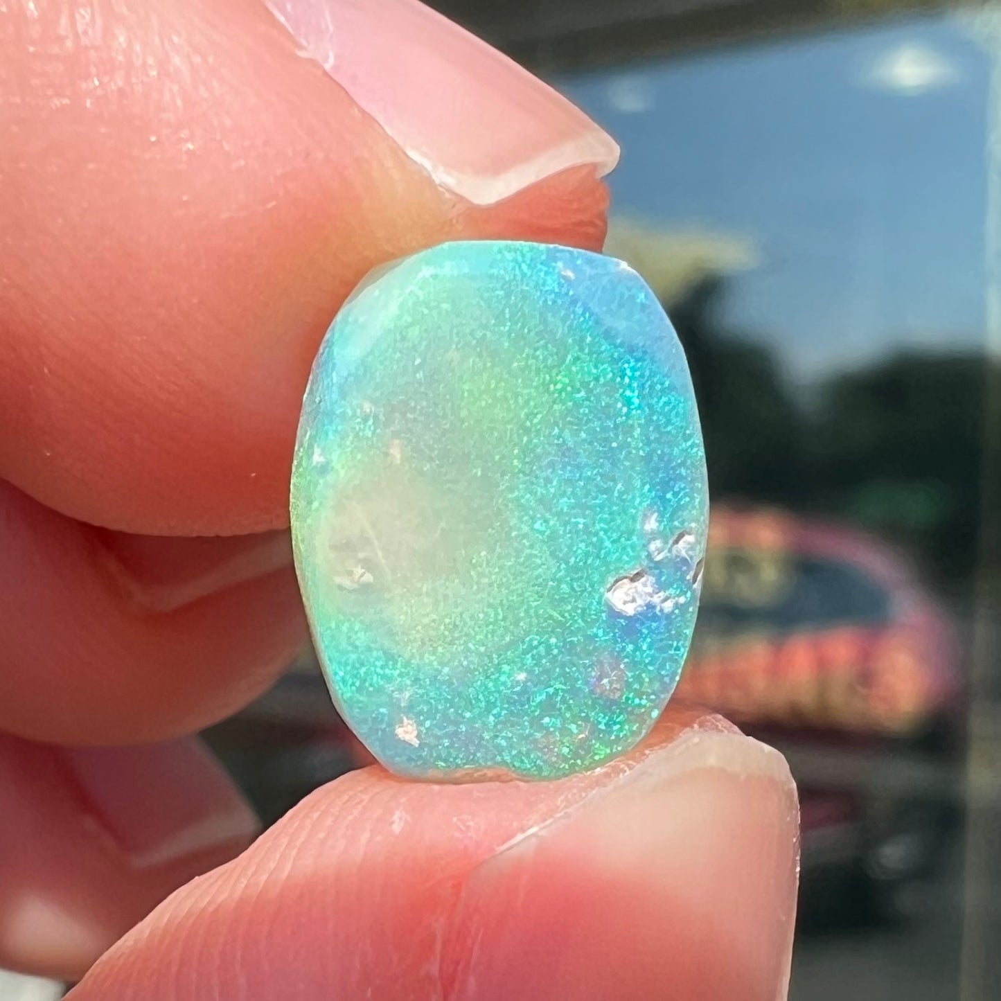 A 2.40ct barrel shaped Lightning Ridge semi-crystal opal. The stone has blue and green colors.