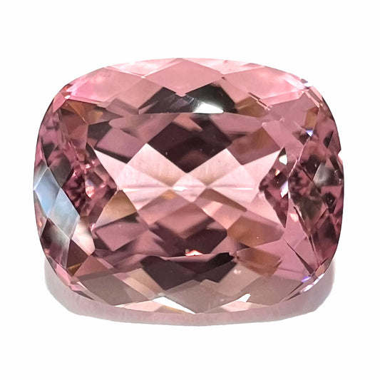 A loose, cushion cut light pink tourmaline gemstone.